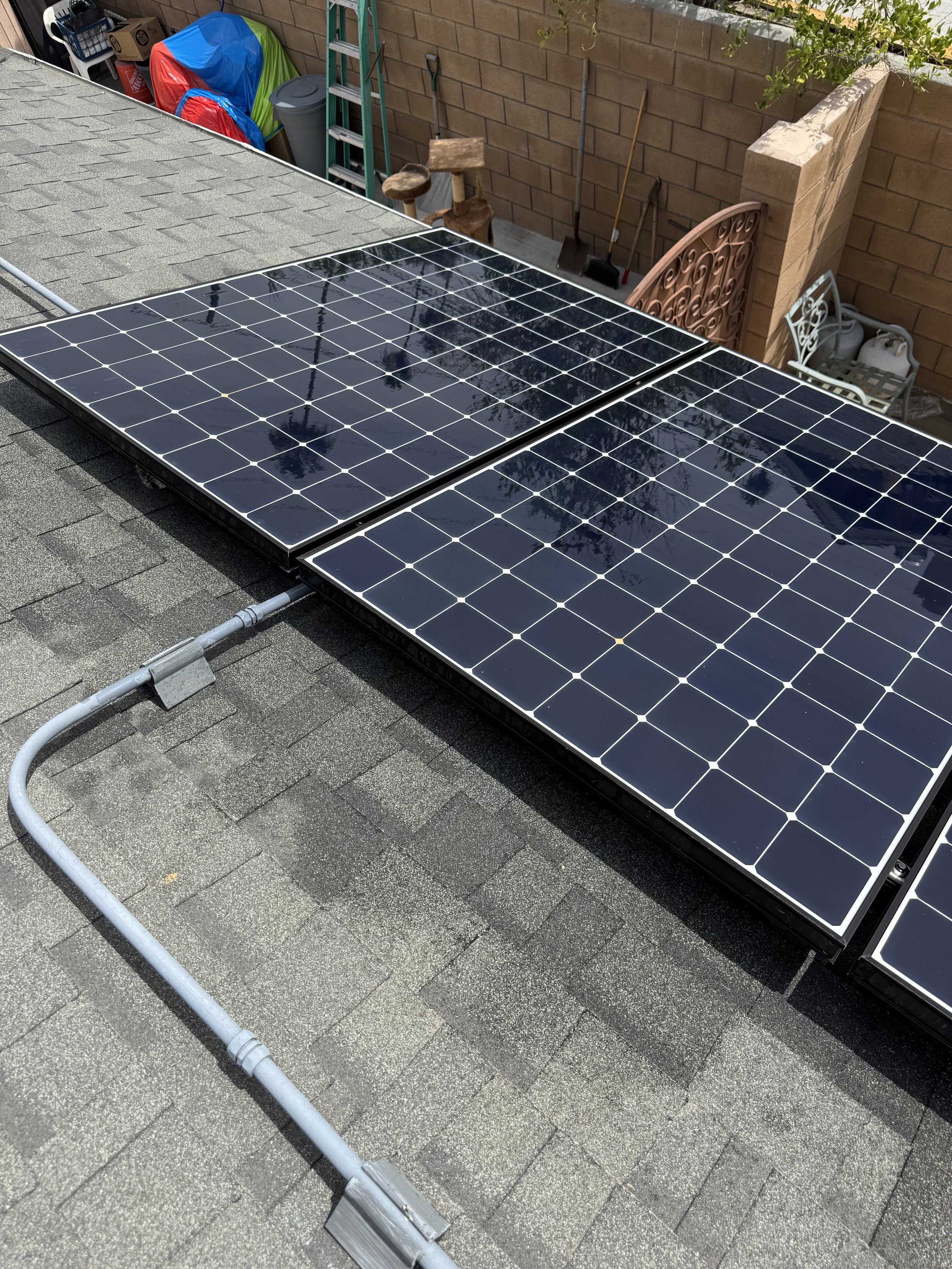 Clean solar panel system mounted on a shingle roof after soft-wash maintenance.