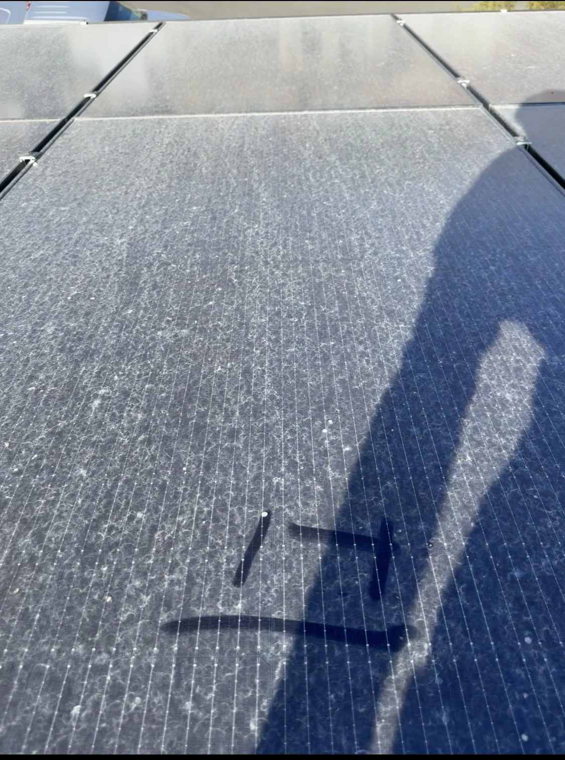 Rooftop solar panel with heavy dust accumulation and water spotting prior to pure-water soft washing.