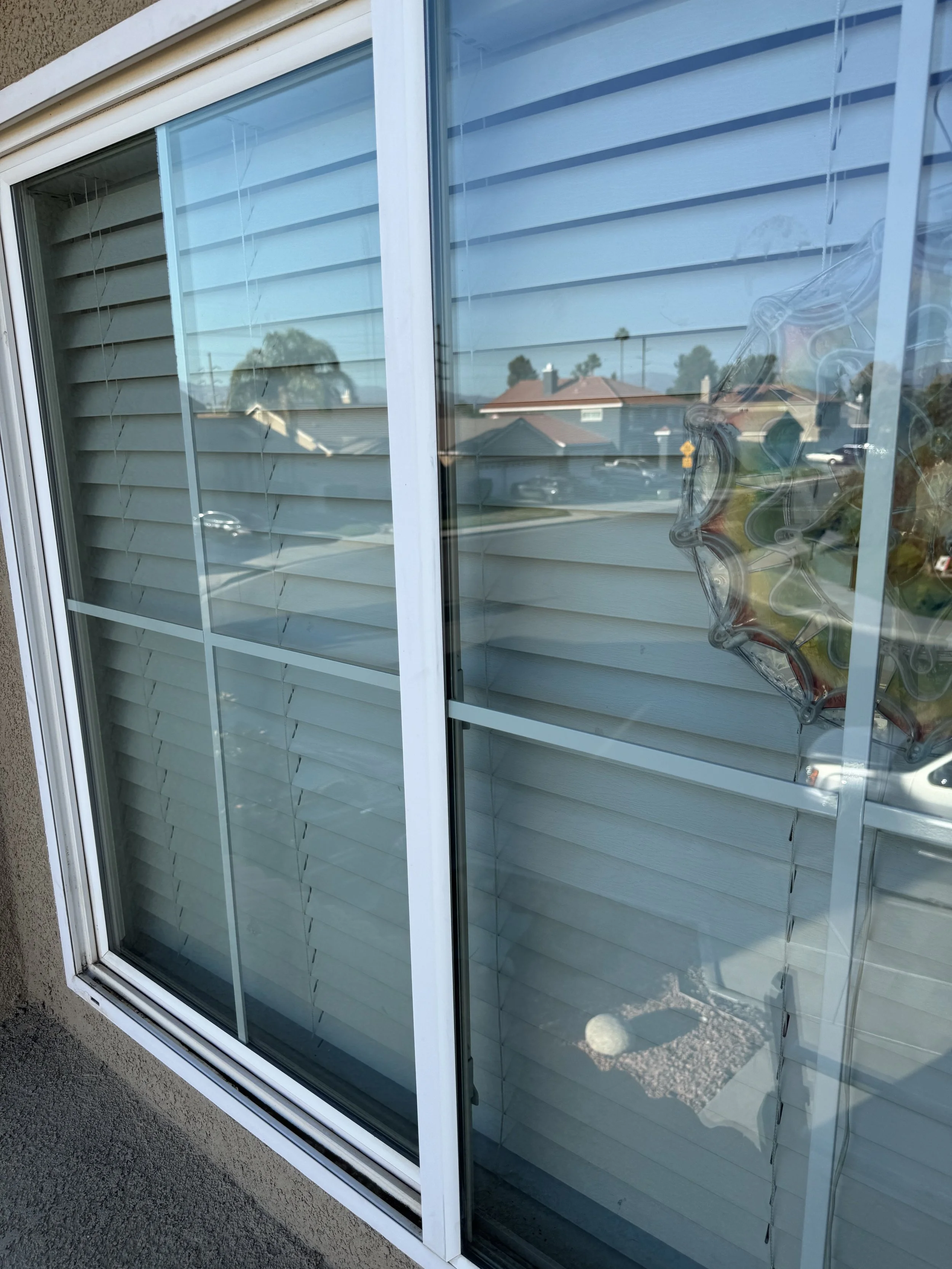 Crystal-clear residential window glass with white frames after professional streak-free washing.