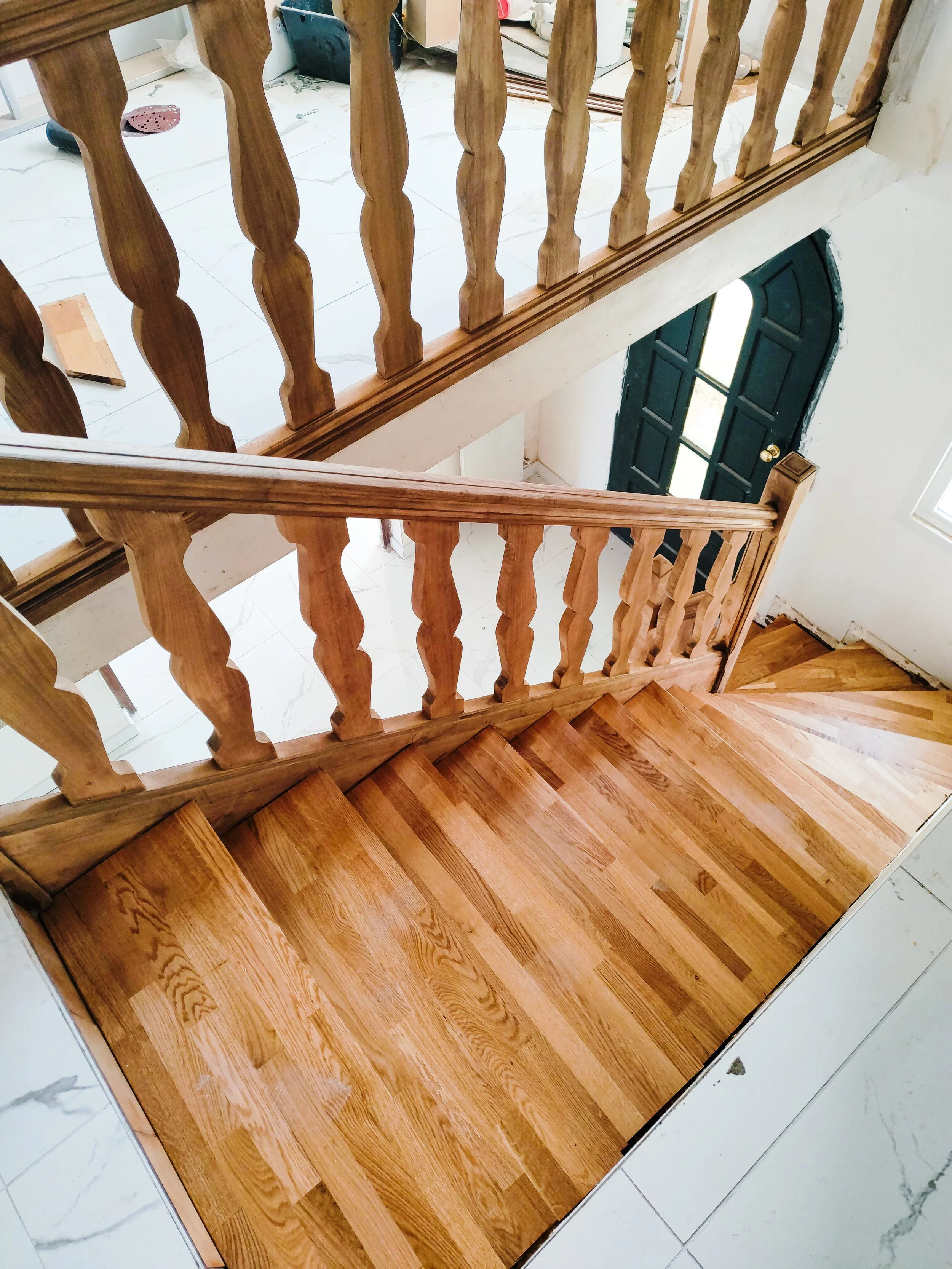Escalier en bois avec rampe et balustrade en bois, vue du haut vers le bas, dans une maison en construction ou rénovée.
