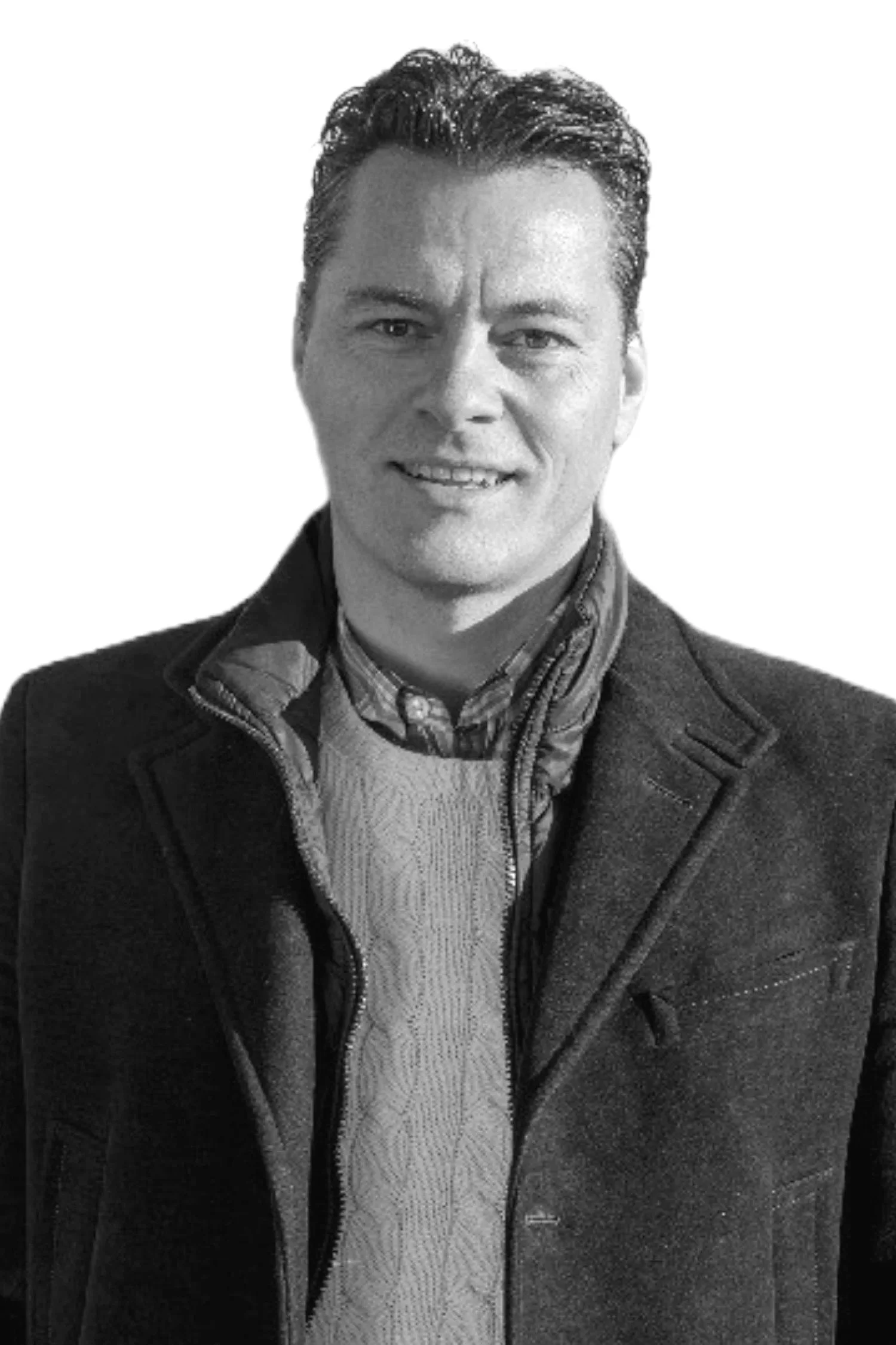 Black and white portrait of a smiling man wearing a jacket, a collared shirt, and a sweater.