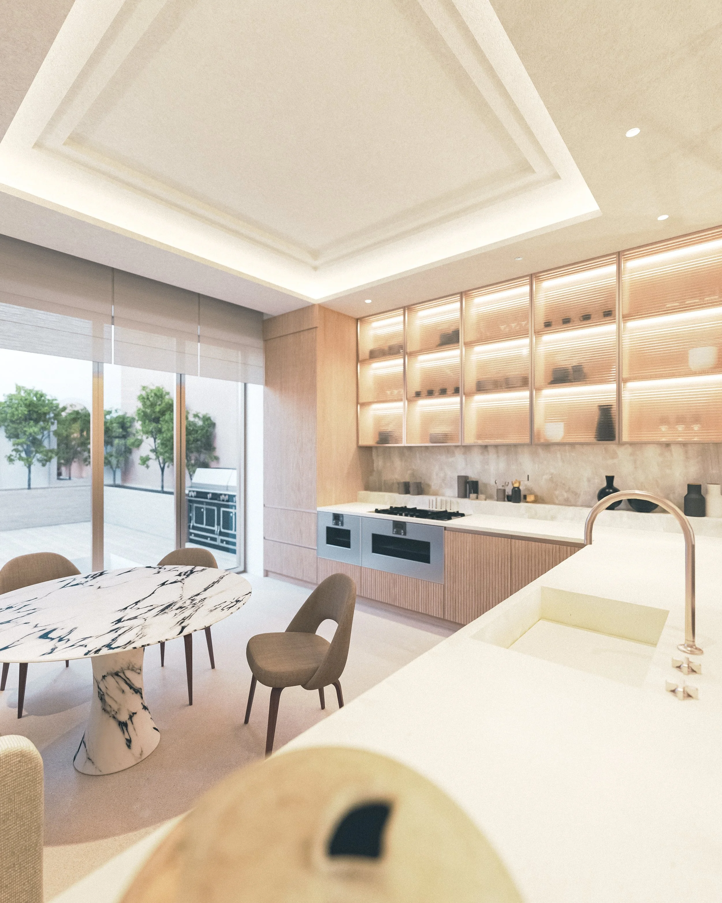 Cuisine moderne avec un espace repas, grande fenêtre avec vue sur des arbres, meubles en bois clair, plan de travail blanc, étagères éclairées, évier, et un îlot central en marbre.