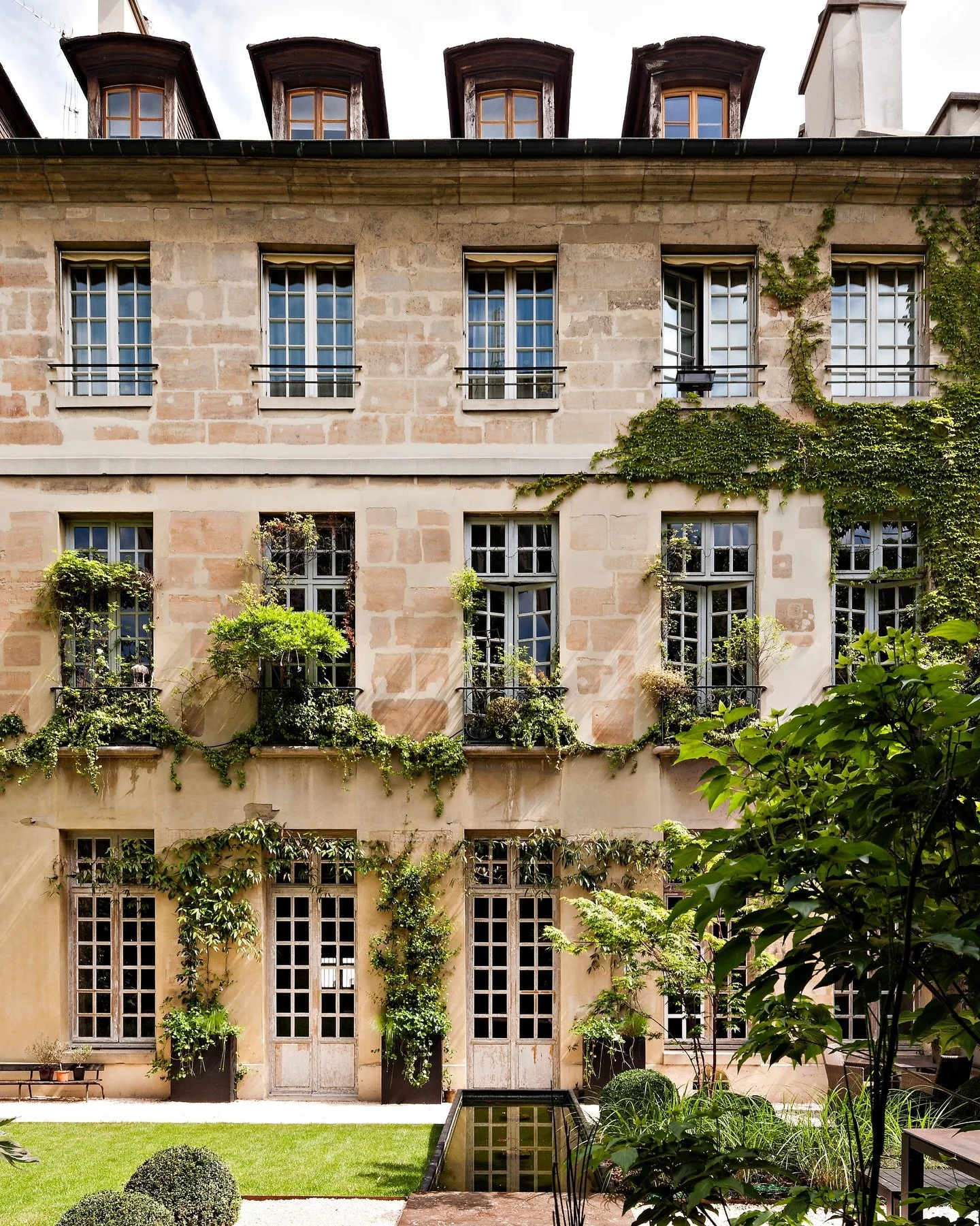 Perle.
A discreet Paris residence where heritage volumes meet contemporary calm. Generous ceiling heights, a garden lined with sculpted boxwood, and a custom library that anchors the entire home define its quiet identity. Warm materials, precise prop