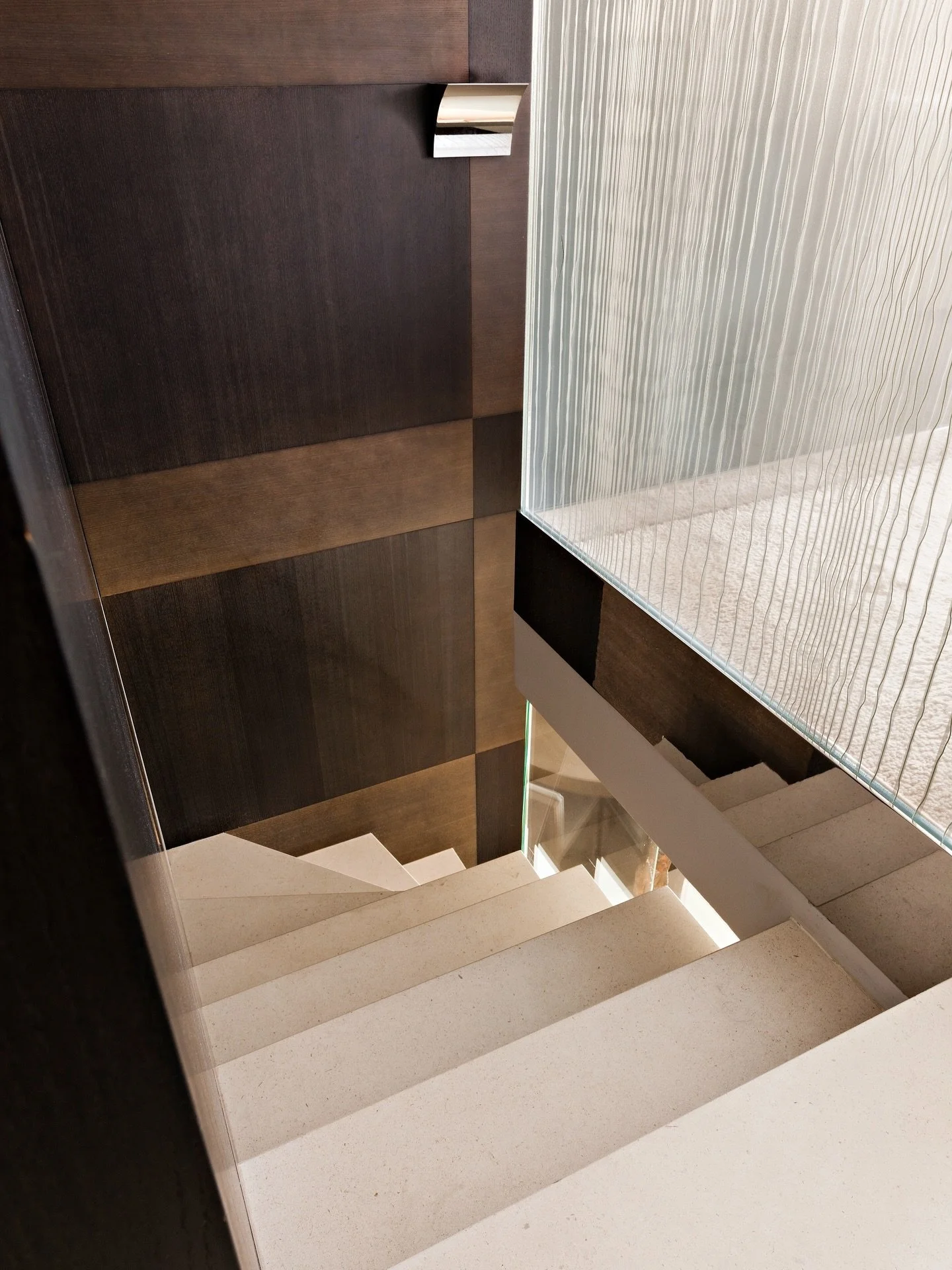 Dark wood panels and light stone steps structure the vertical circulation. Textured glass introduces softness while reinforcing the architectural rhythm of the stairwell.

Styling and decoration by @heleneguillonensembliere
Photo : @jopauwelsphotogra