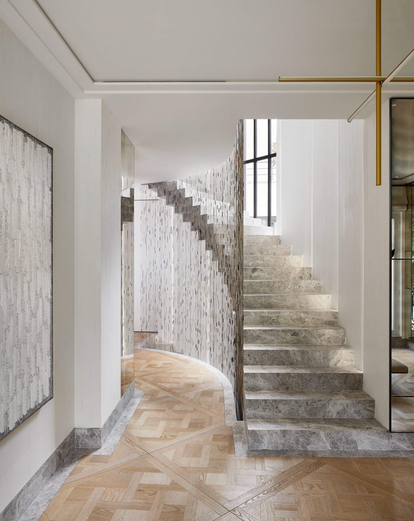 A subtle interplay of curves, textures and light. The staircase unfolds as a sculptural element, where mineral surfaces contrast with the warmth of patterned wood flooring. A composition shaped by precision, fluidity and refined detailing.

Styling &