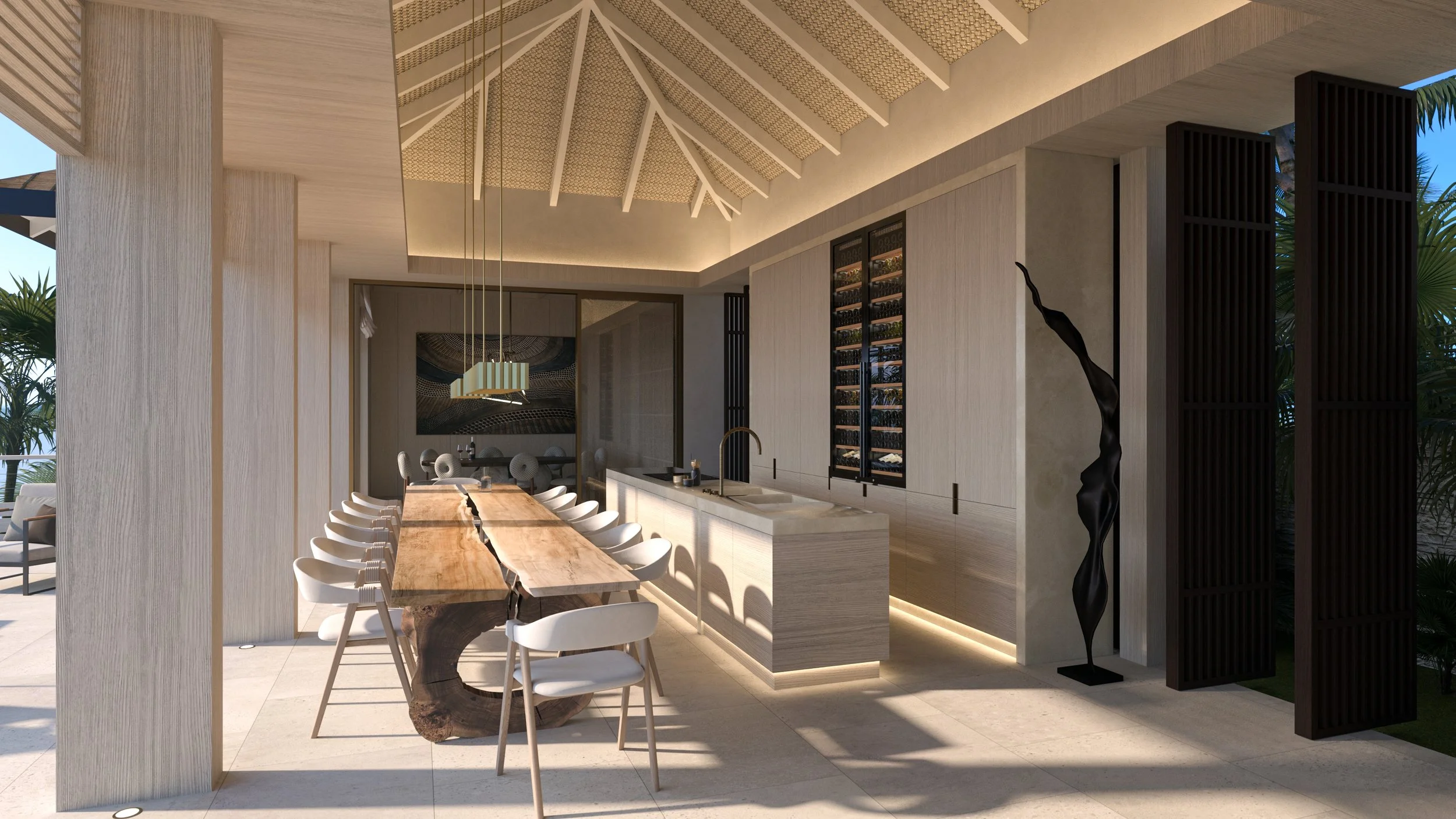 Intérieur d'une cuisine moderne avec un grand plan de travail en marbre, un mur avec cave à vin intégrée, et une grande table en bois avec des chaises blanches, dans un design minimaliste et lumineux.