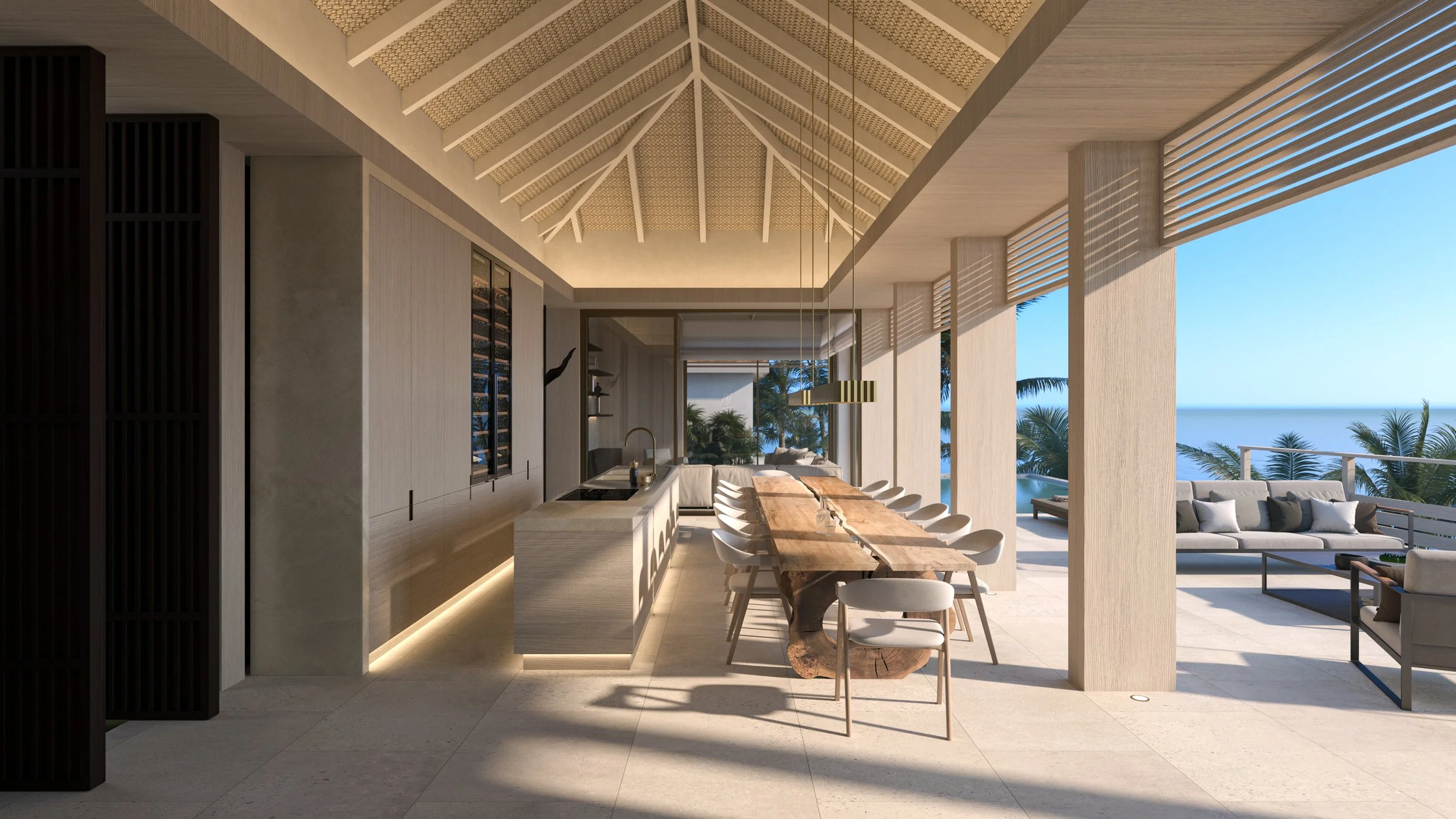 Intérieur d'une salle à manger moderne avec vue sur la mer, comprenant une grande table en bois, des chaises blanches, un coin salon extérieur avec canapé et vue sur des palmiers.
