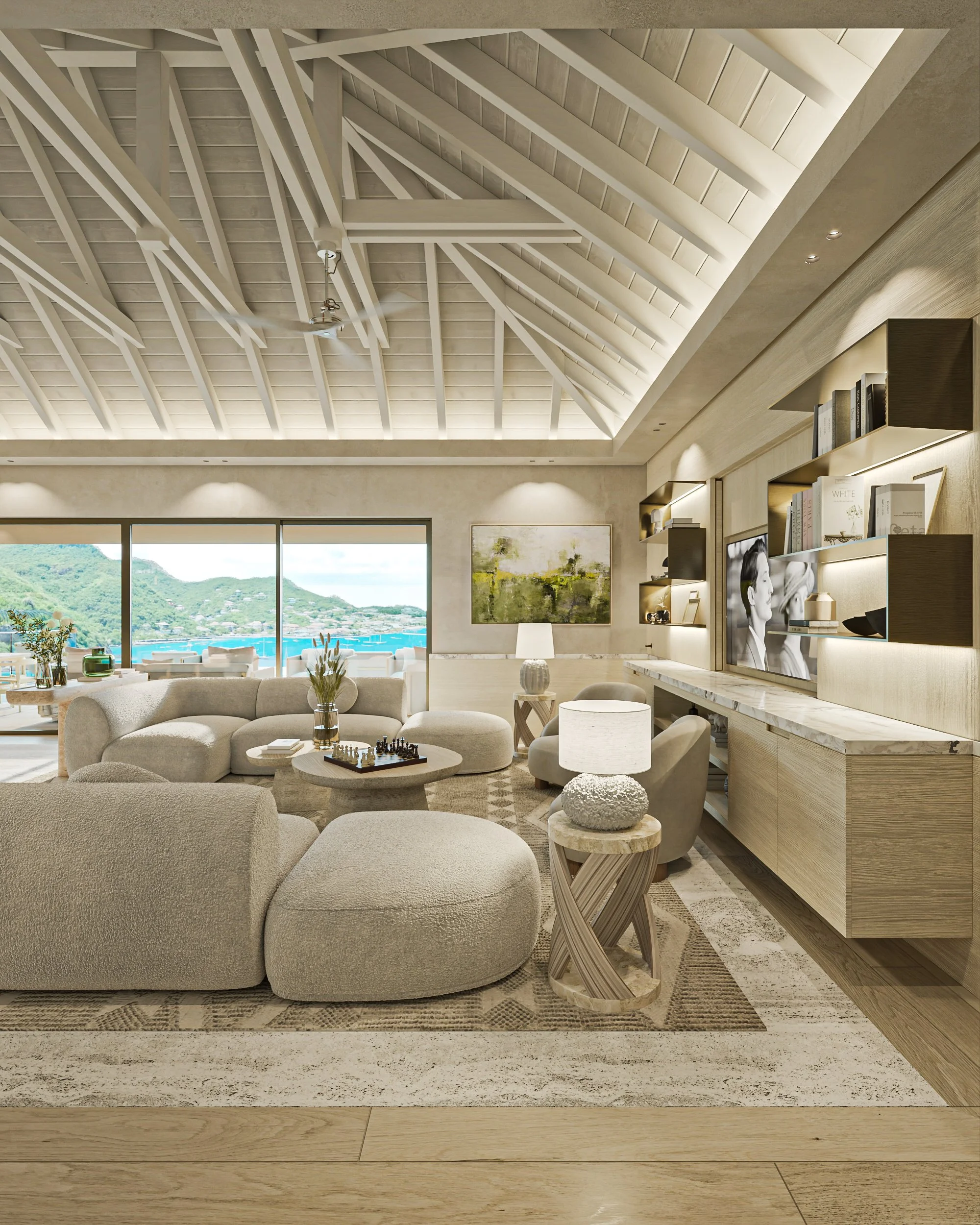 Salon moderne avec canapé beige, table basse, lampes, bibliothèque avec télévision, grande fenêtre donnant sur une vue de la mer et de la montagne, décoration épurée et lumineuse.