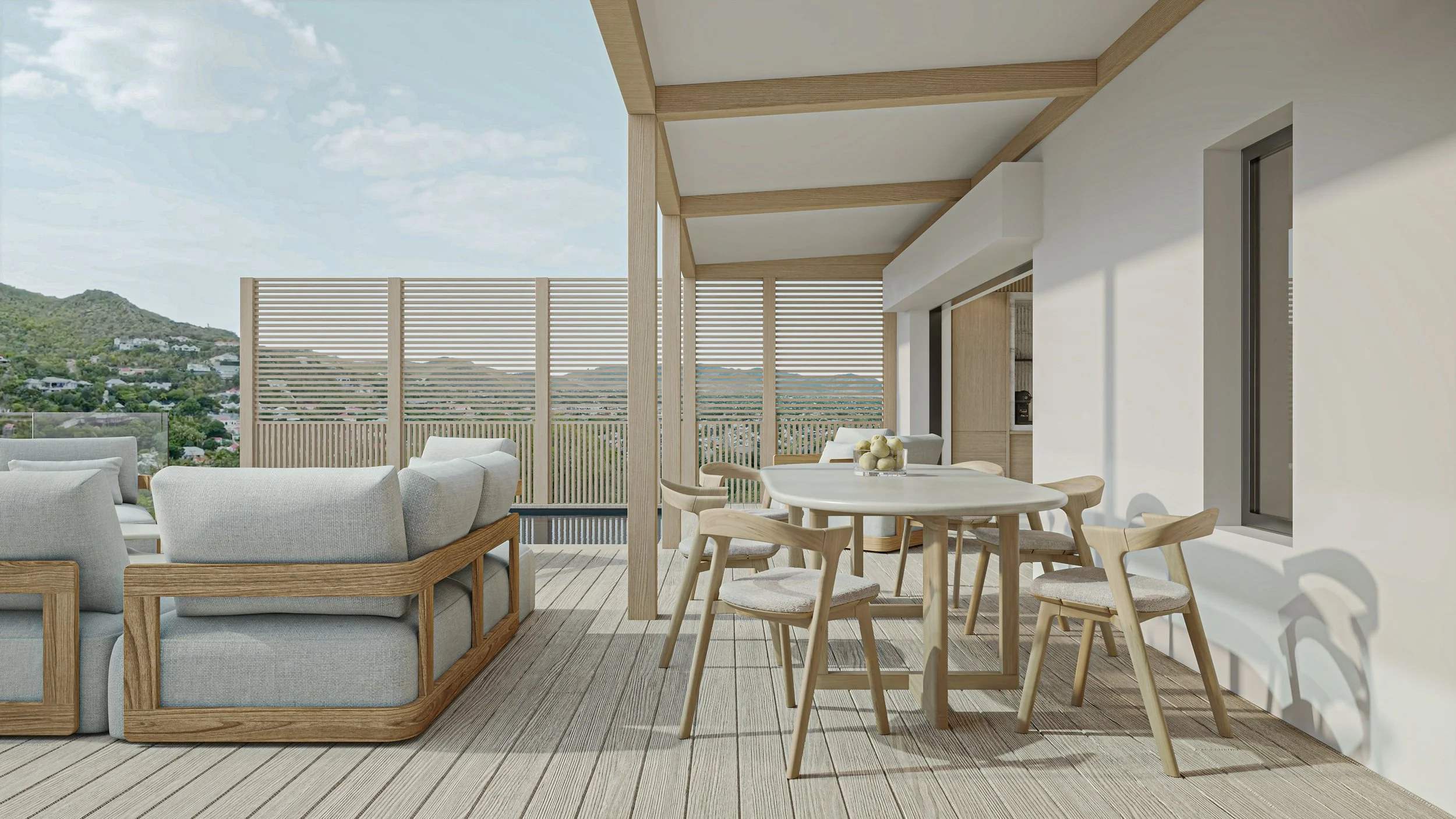 Terrasse extérieure avec meubles en bois clair, comprenant un canapé, une table ronde et plusieurs chaises. L'espace est en partie ombragé, avec un mur en lattes en arrière-plan et une vue sur des collines et des maisons sous un ciel partiellement nu