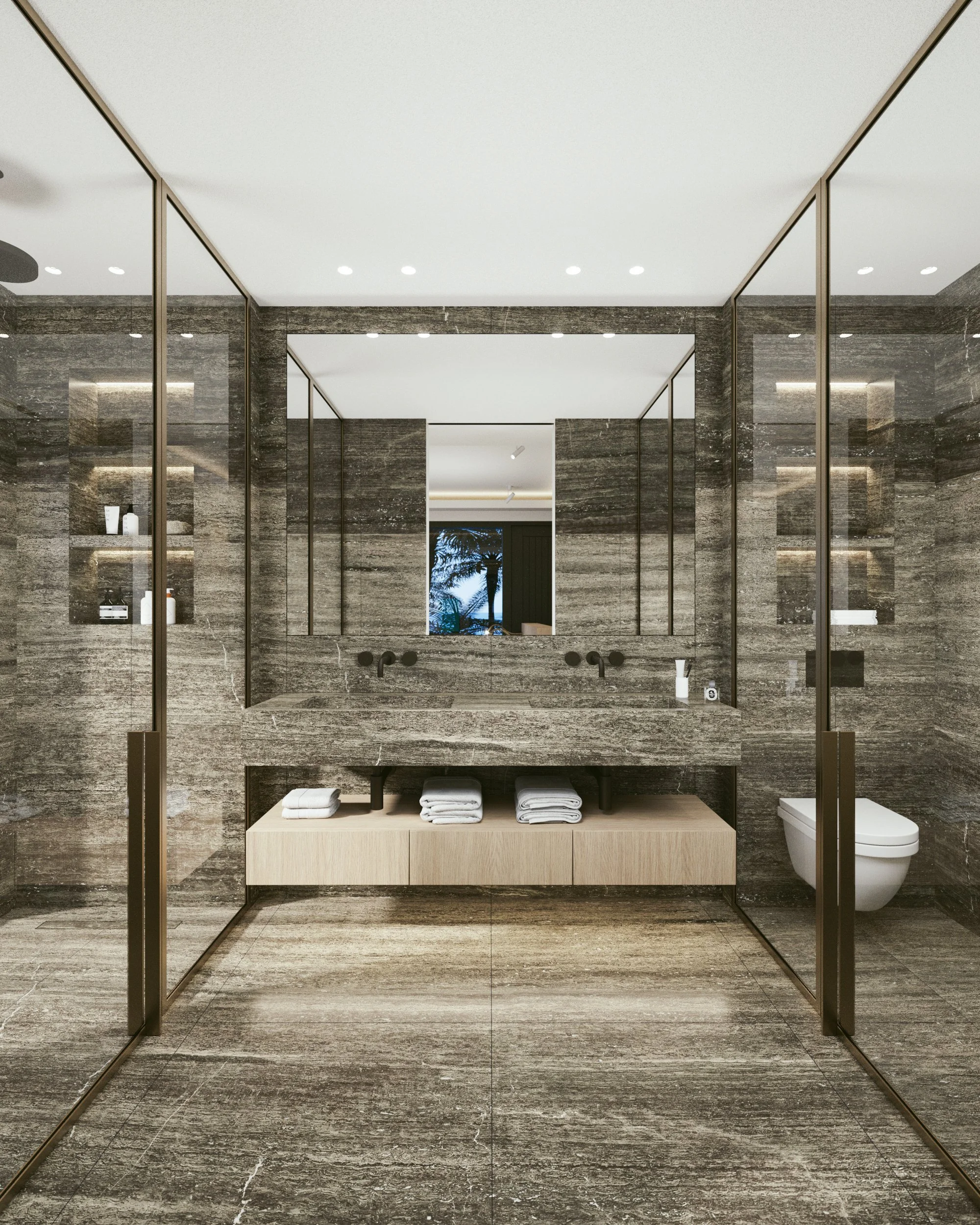 Salle de bain moderne avec murs et sol en pierre, grande miroir, lavabo en pierre avec rangement en dessous, toilettes, étagères avec produits de toilette, et porte en verre.