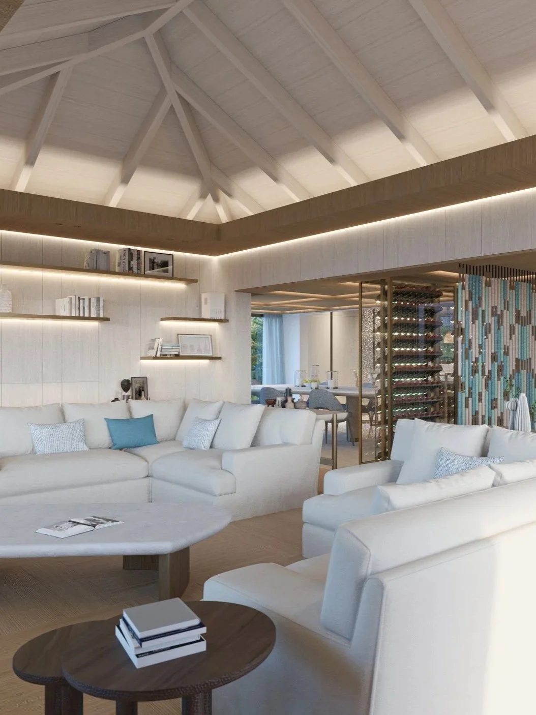 Salon moderne avec canapés blancs, étagères en bois avec livres, espace cuisine en arrière-plan, décoration élégante et lumineuse, et une partie d'une cave à vin visible.