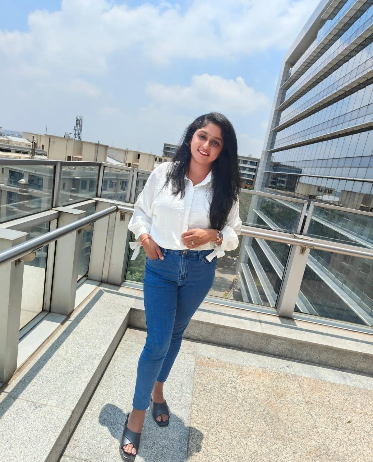 Official portrait of the Founder of Margin Arch Consulting, Varshitha B, pictured at the ITC Limited cityscape balcony, representing the firm's institutional corporate roots.