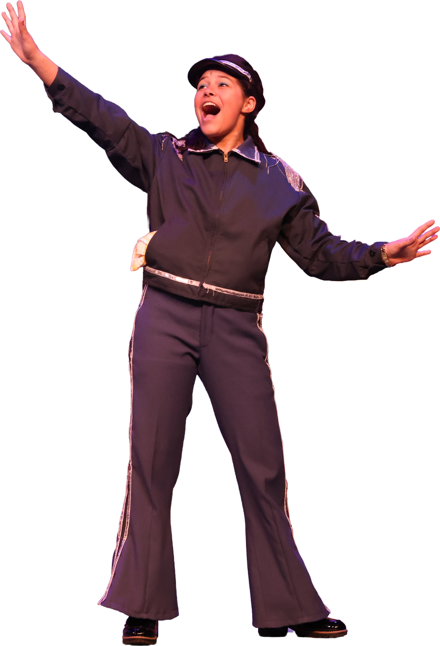 A young woman wearing a dark jacket and pants, with a hat, raising one arm and smiling.