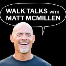 A smiling man with a bald head and beard wearing a black shirt, with a speech bubble that says 'Walk Talks with Matt McMillen' against a black background.