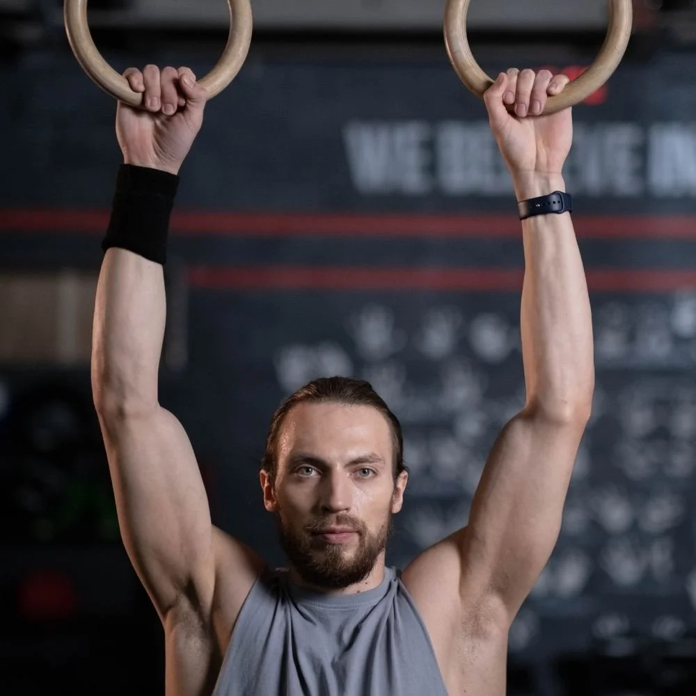 Man doing ring muscle up in an environmentally conscious gym