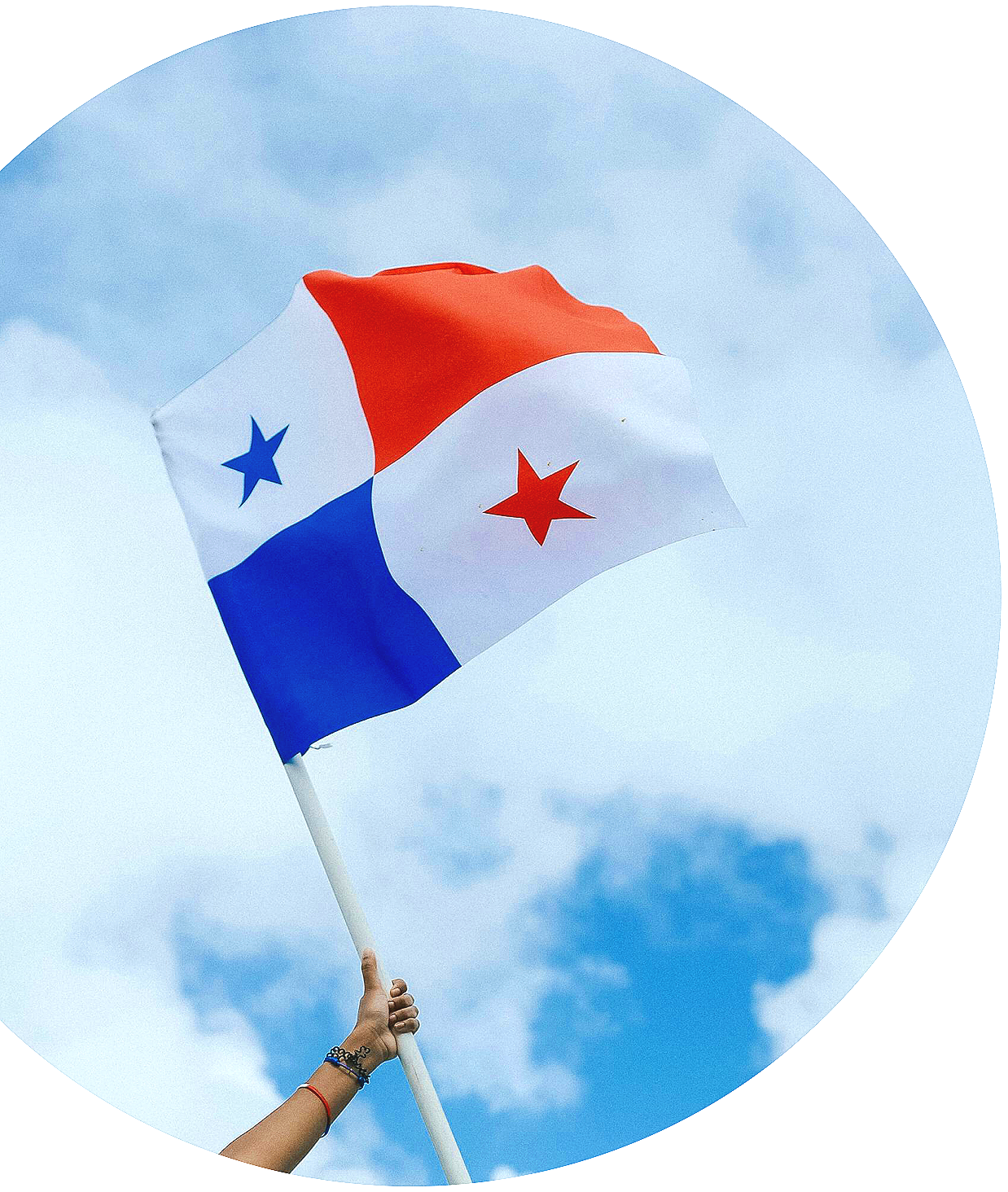 A person holding a Panamanian flag that features horizontal stripes in red, white, and blue, with red and blue stars, waving against a cloudy sky.