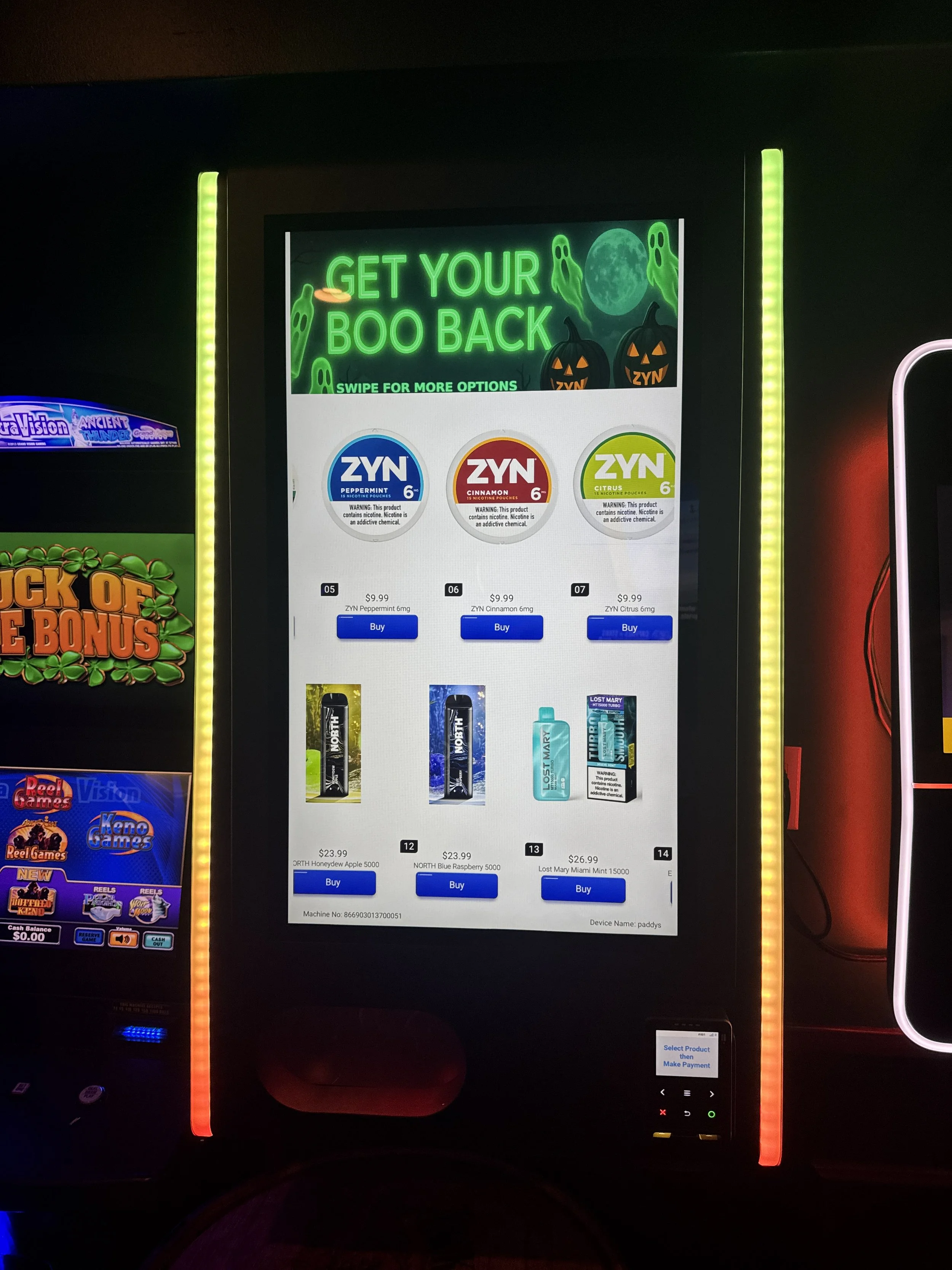 Digital vending machine advertising Halloween-themed products with neon sign that reads 'Get Your Boo Back' and options for ZYN nicotine pouches and other items.