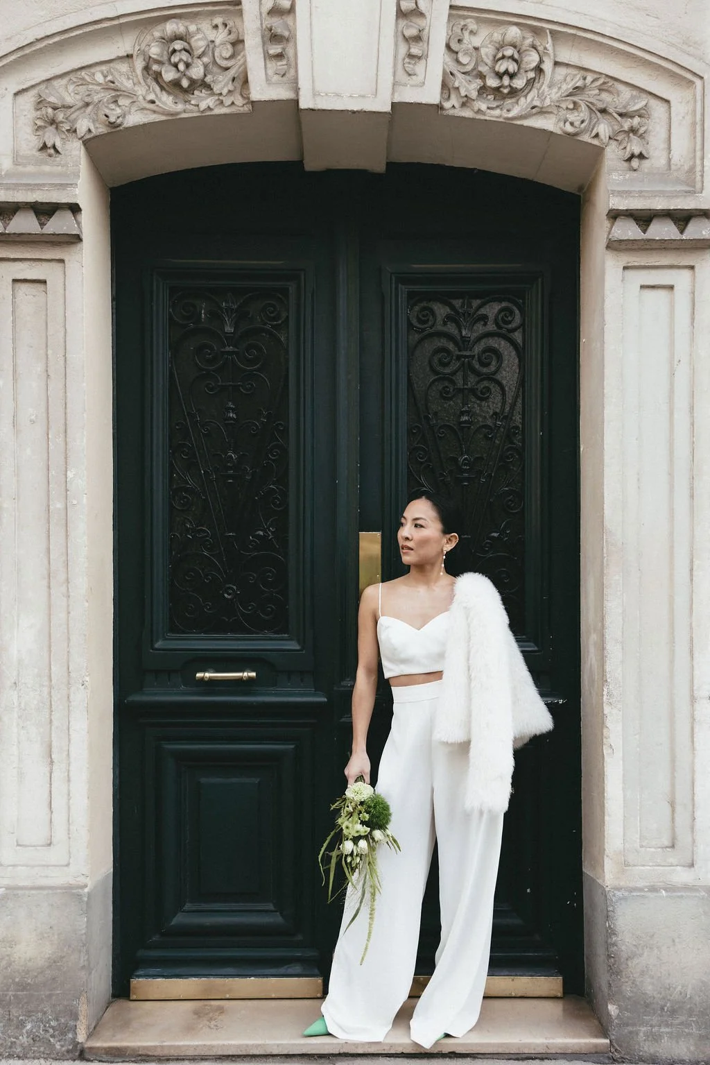 Mariée contemporaine posant devant une porte haussmannienne, incarnation d’un mariage civil élégant et urbain.