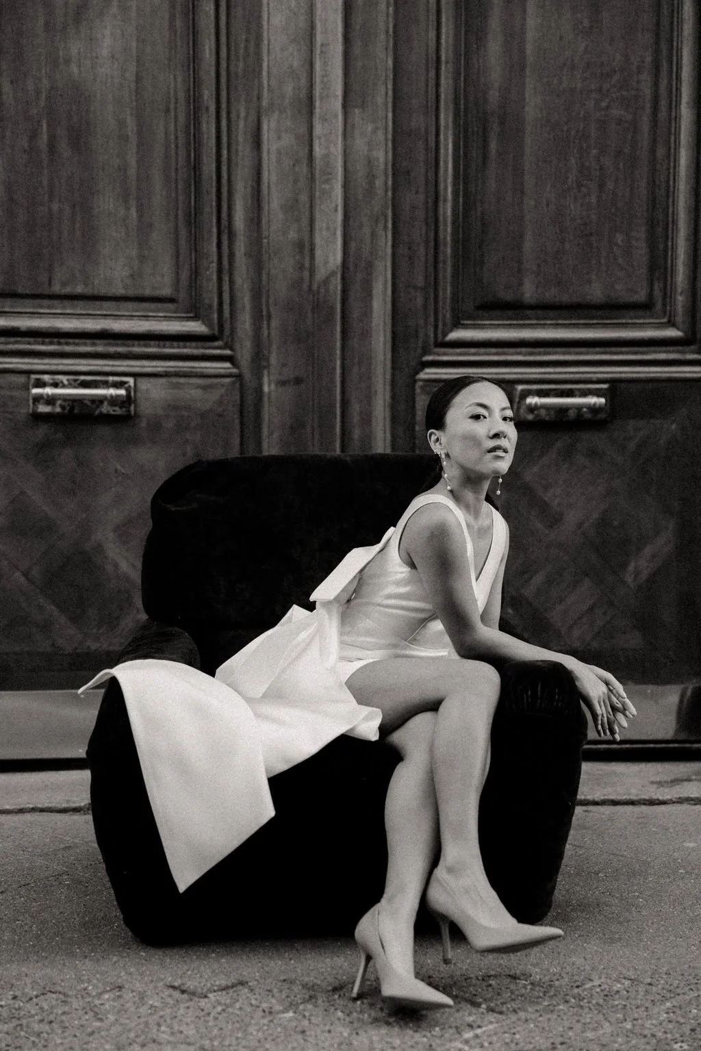 Mariée assise sur un fauteuil, pose éditoriale mêlant élégance, modernité et audace.