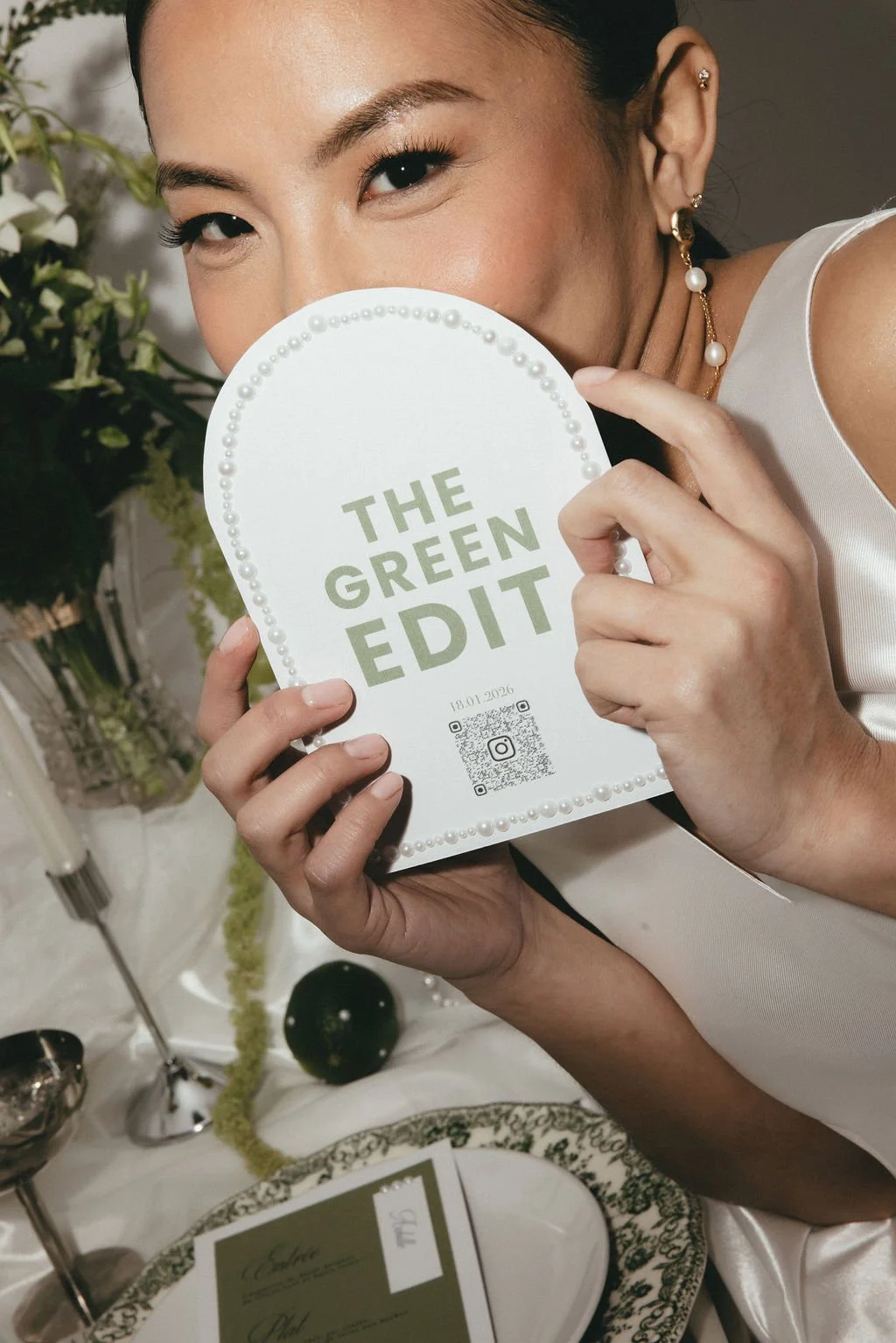 Mariée tenant une carte THE GREEN EDIT, symbole d’un univers mariage élégant et contemporain.