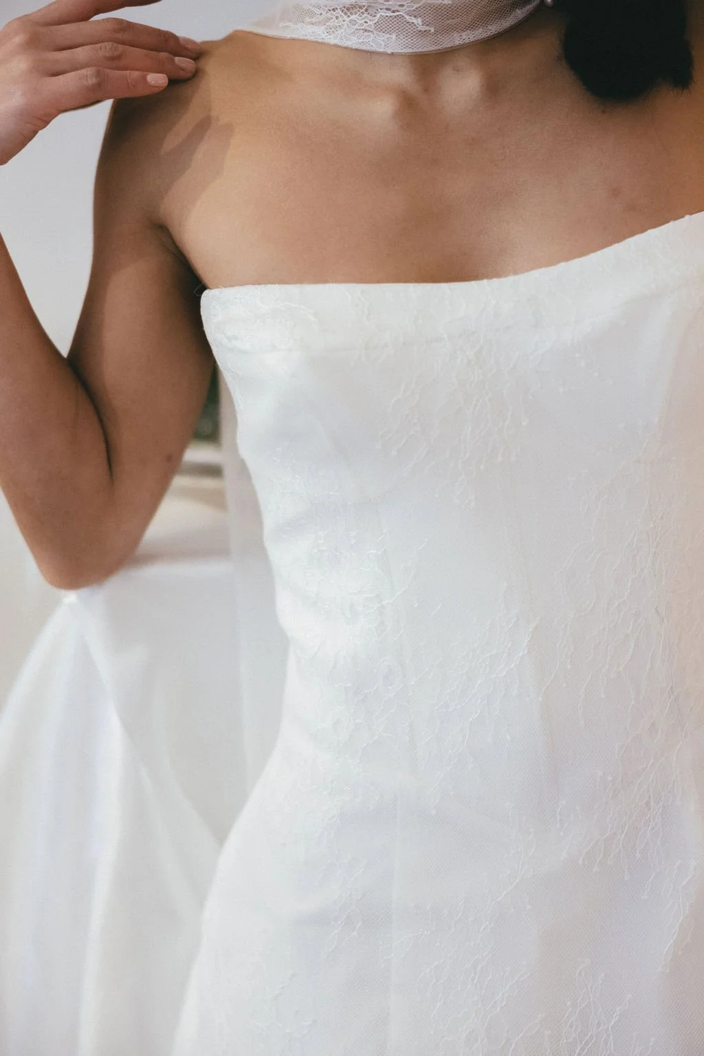 Mariée en robe courte blanche en dentelle, lignes épurées et allure contemporaine.