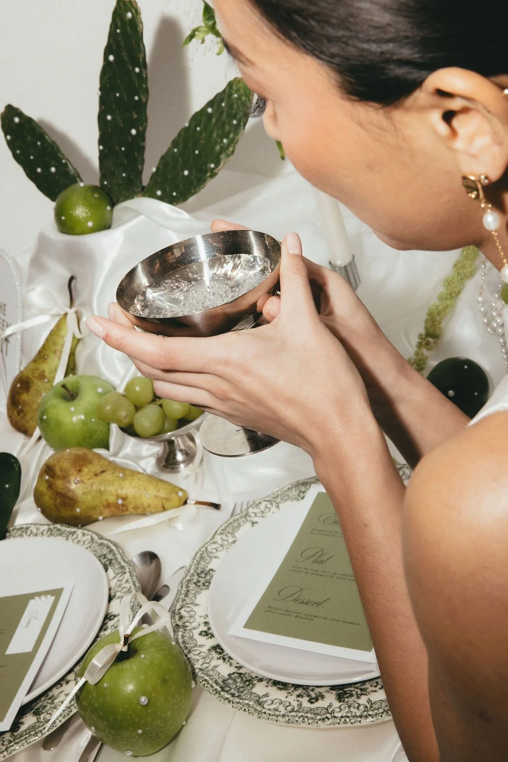 Mariée tenant une coupe, scène de table moderne et raffinée.