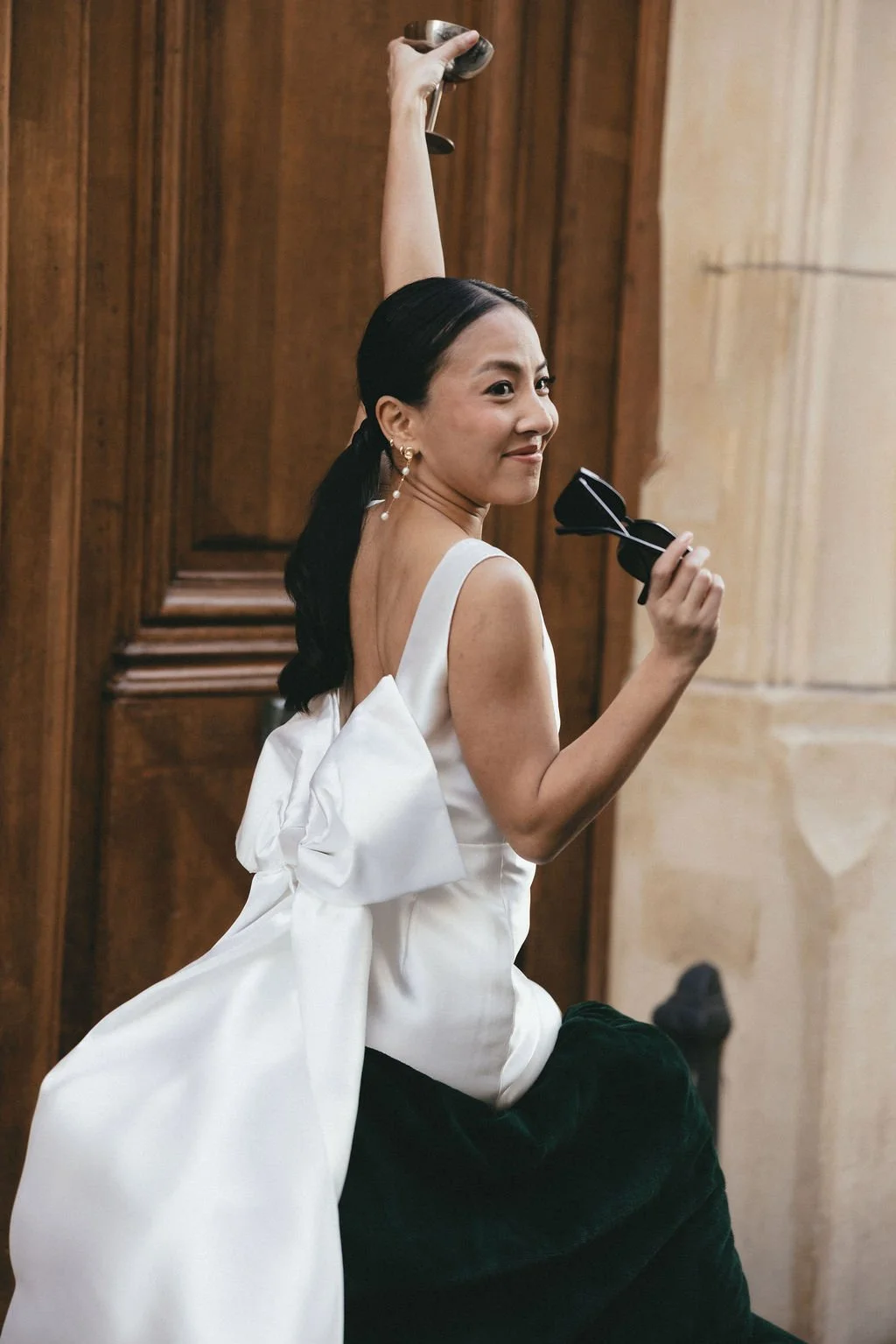 Mariée moderne portant des lunettes de soleil et un cocktail, vision décontractée et élégante du mariage civil.