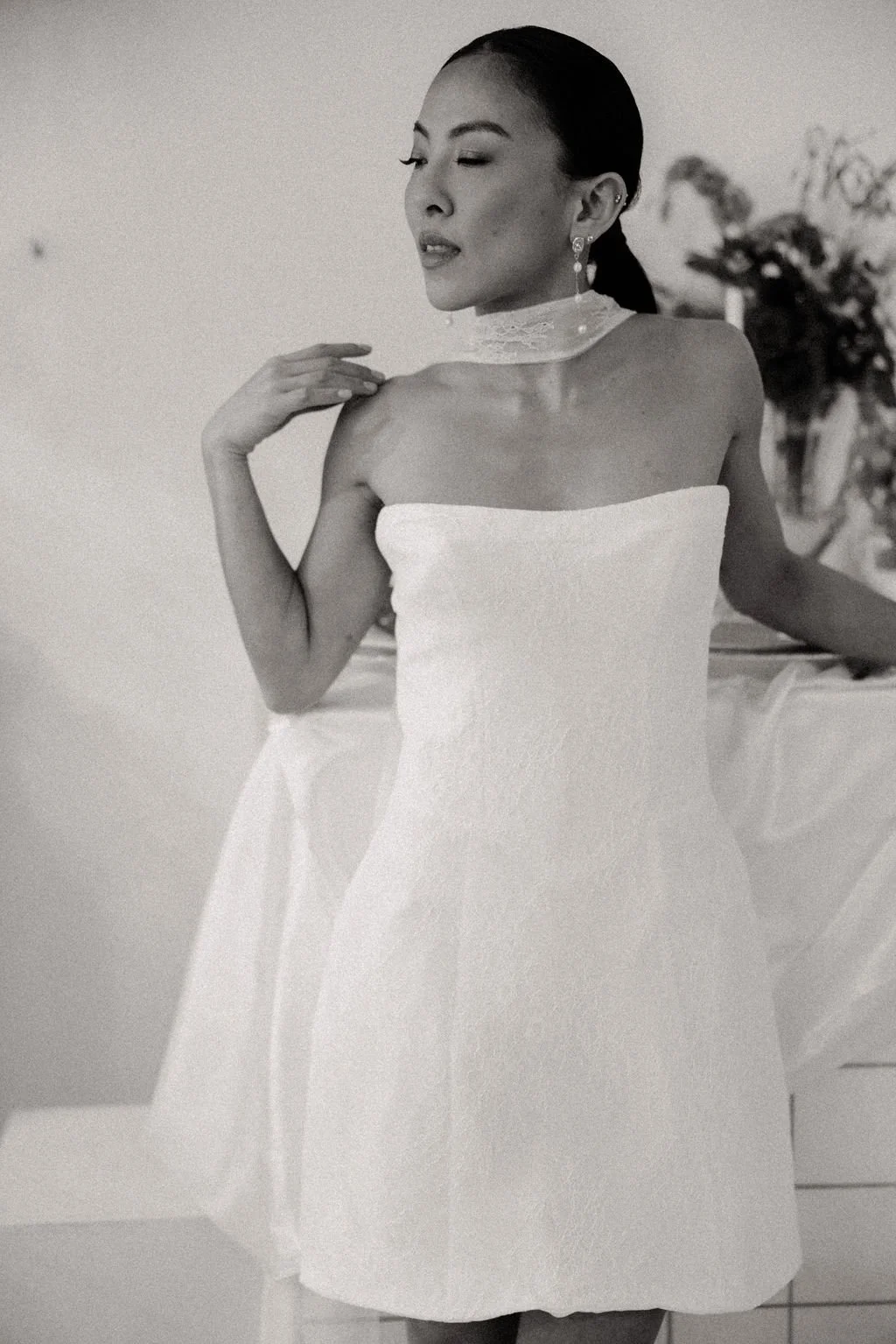 Mariée en robe courte blanche en dentelle, lignes épurées et allure contemporaine.