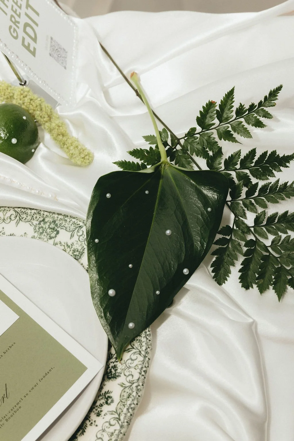 Feuilles vertes ornées de perles pour une décoration de mariage délicate et organique.