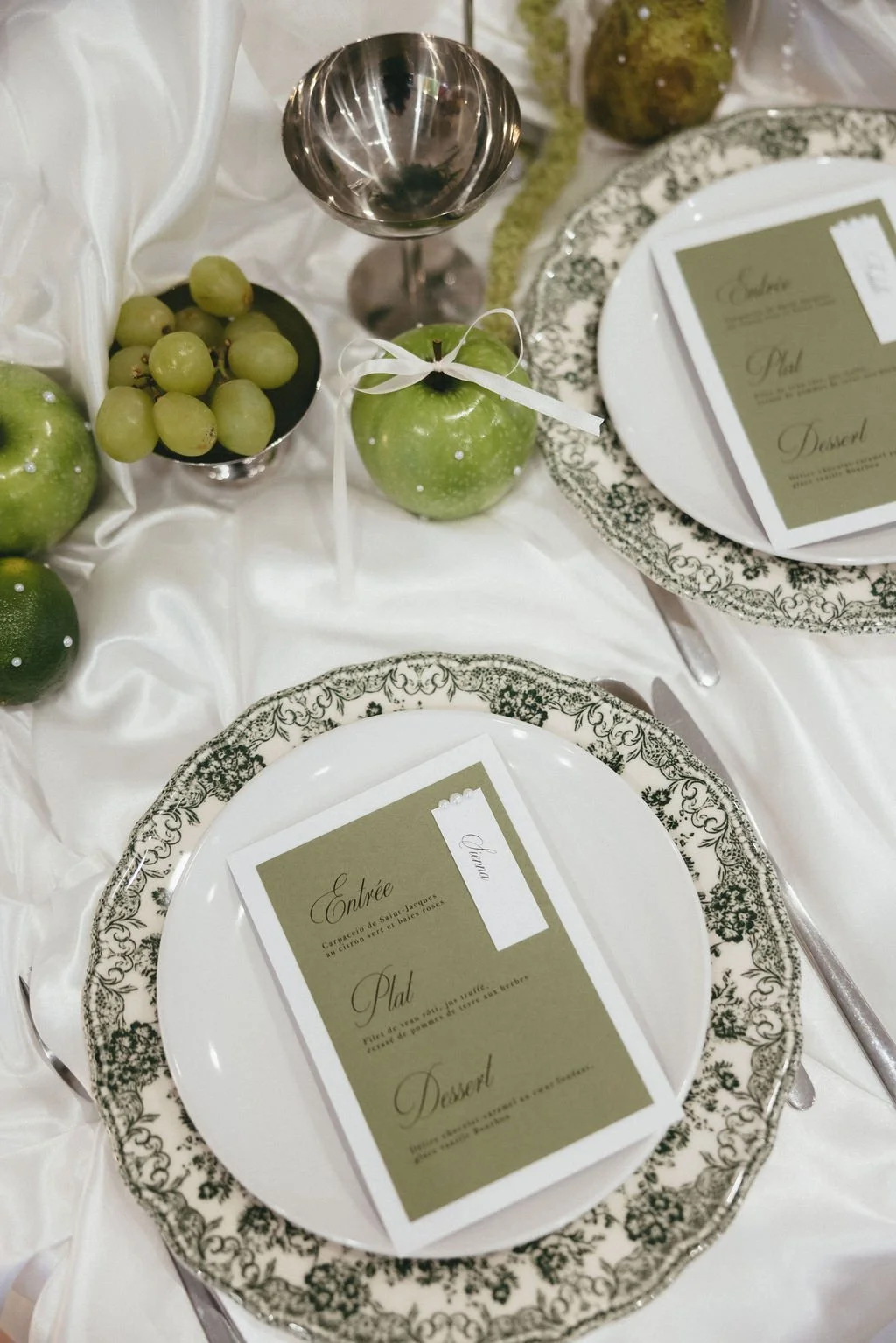Table de mariage décorée de fruits verts et de vaisselle élégante, pour une ambiance naturelle et sophistiquée.