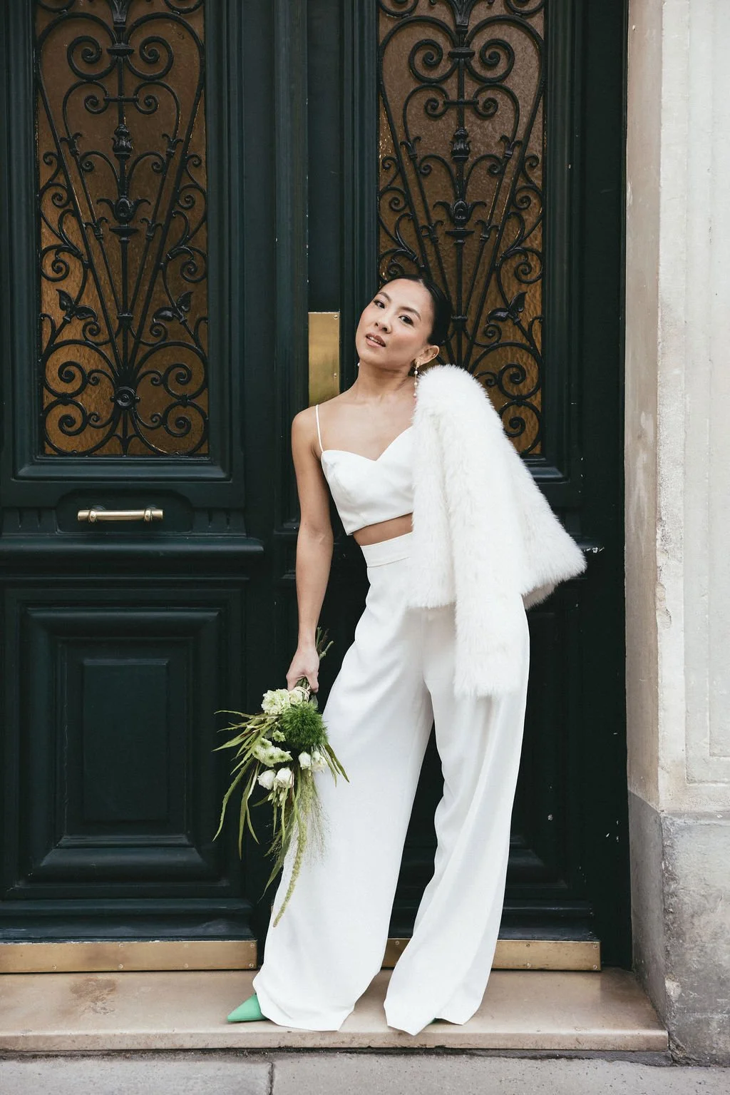 Mariée contemporaine posant devant une porte haussmannienne, incarnation d’un mariage civil élégant et urbain.