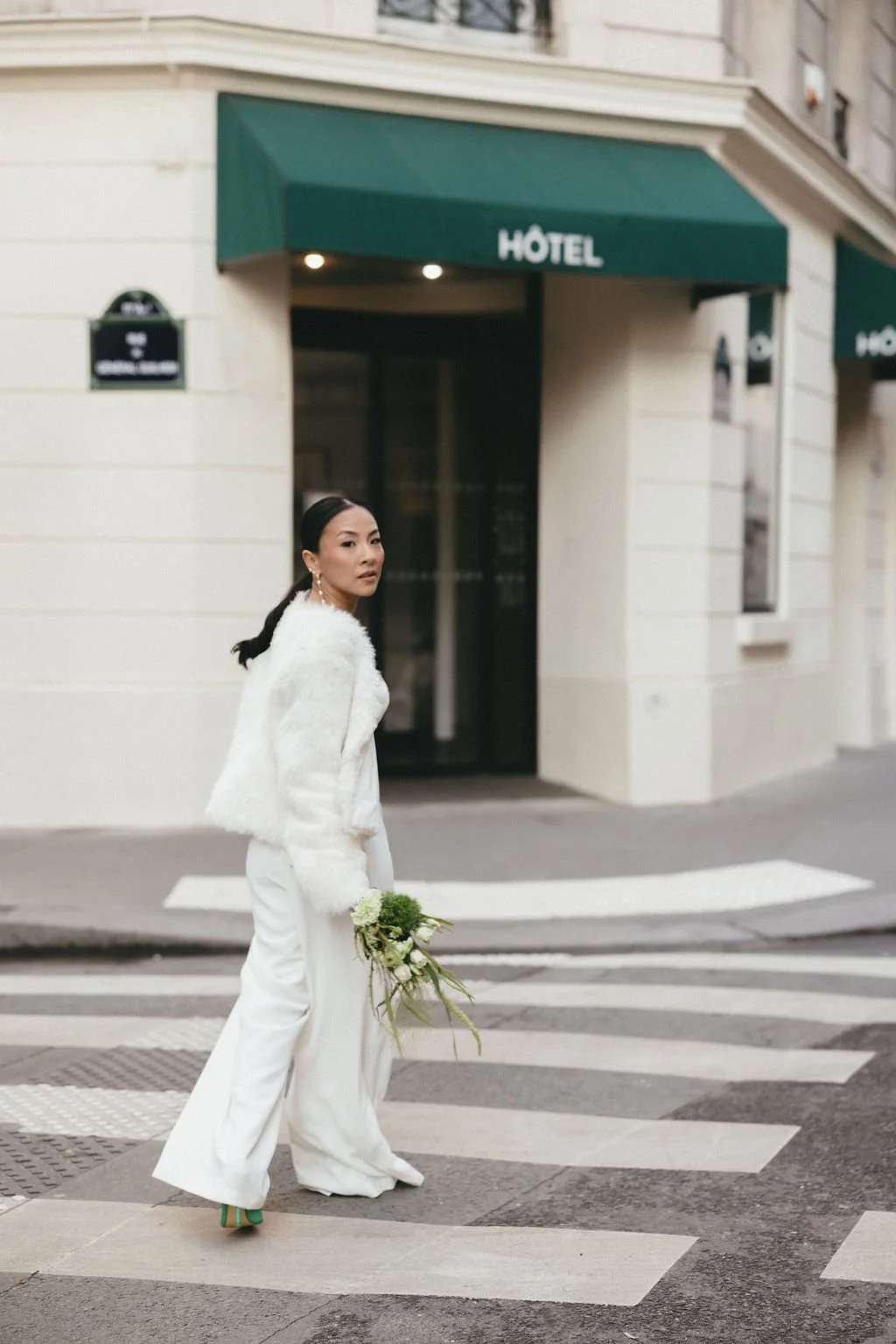 Mariée en tenue blanche traversant un passage piéton, symbole d’un mariage urbain et contemporain.