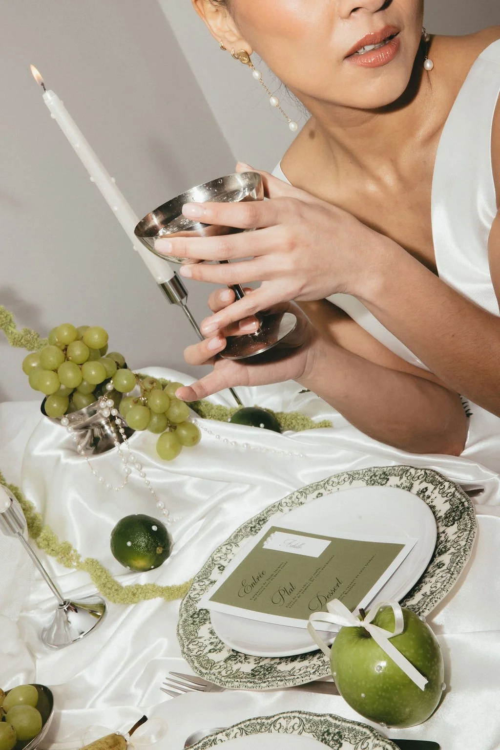Mariée tenant une coupe, scène de table moderne et raffinée.