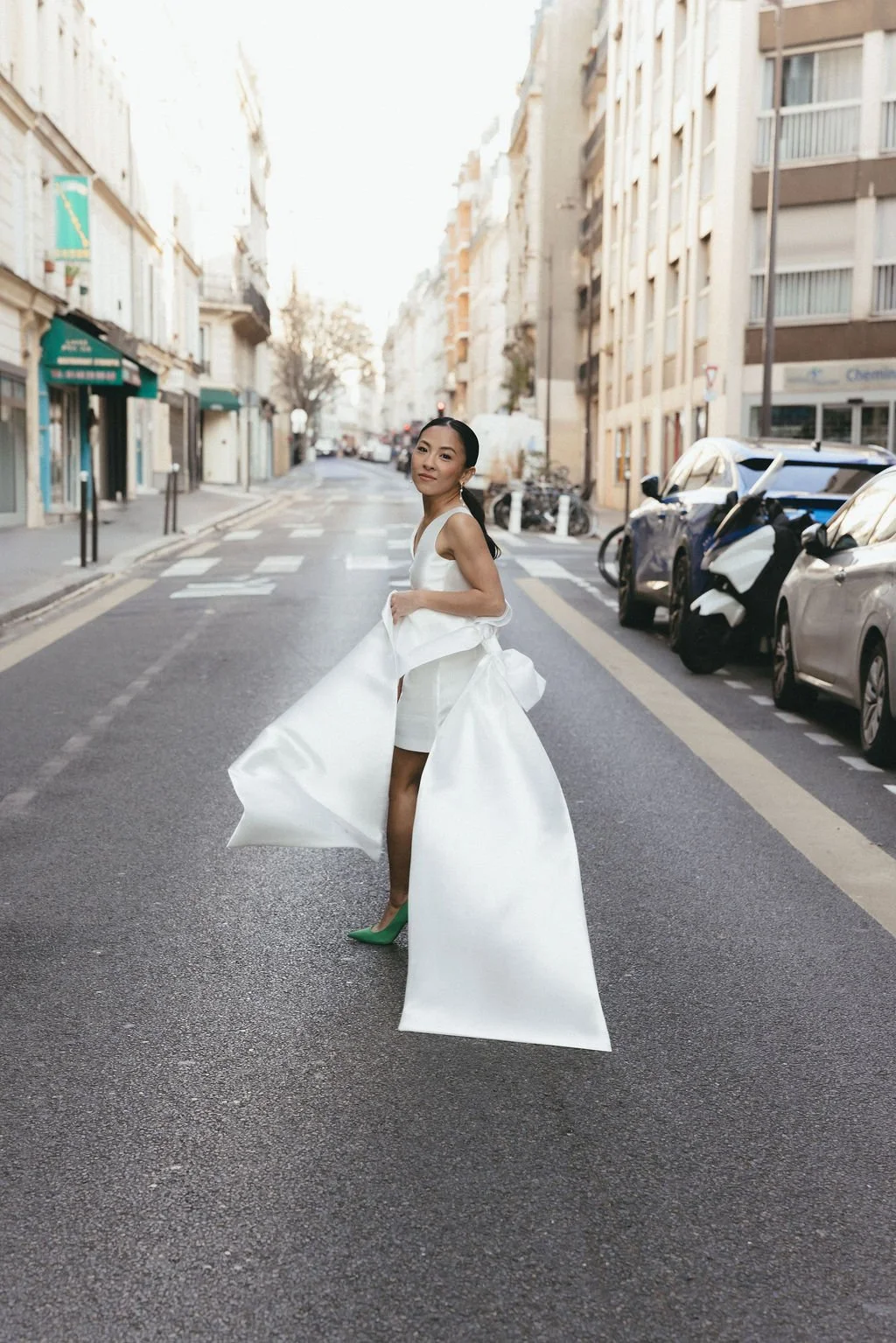 Mariée tournoyant dans une rue urbaine, célébration du mouvement et de la liberté.