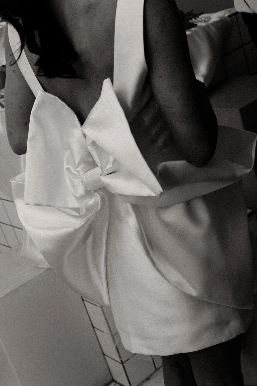 Vue arrière de la robe de mariée en noir et blanc, nœud graphique et élégance éditoriale.
