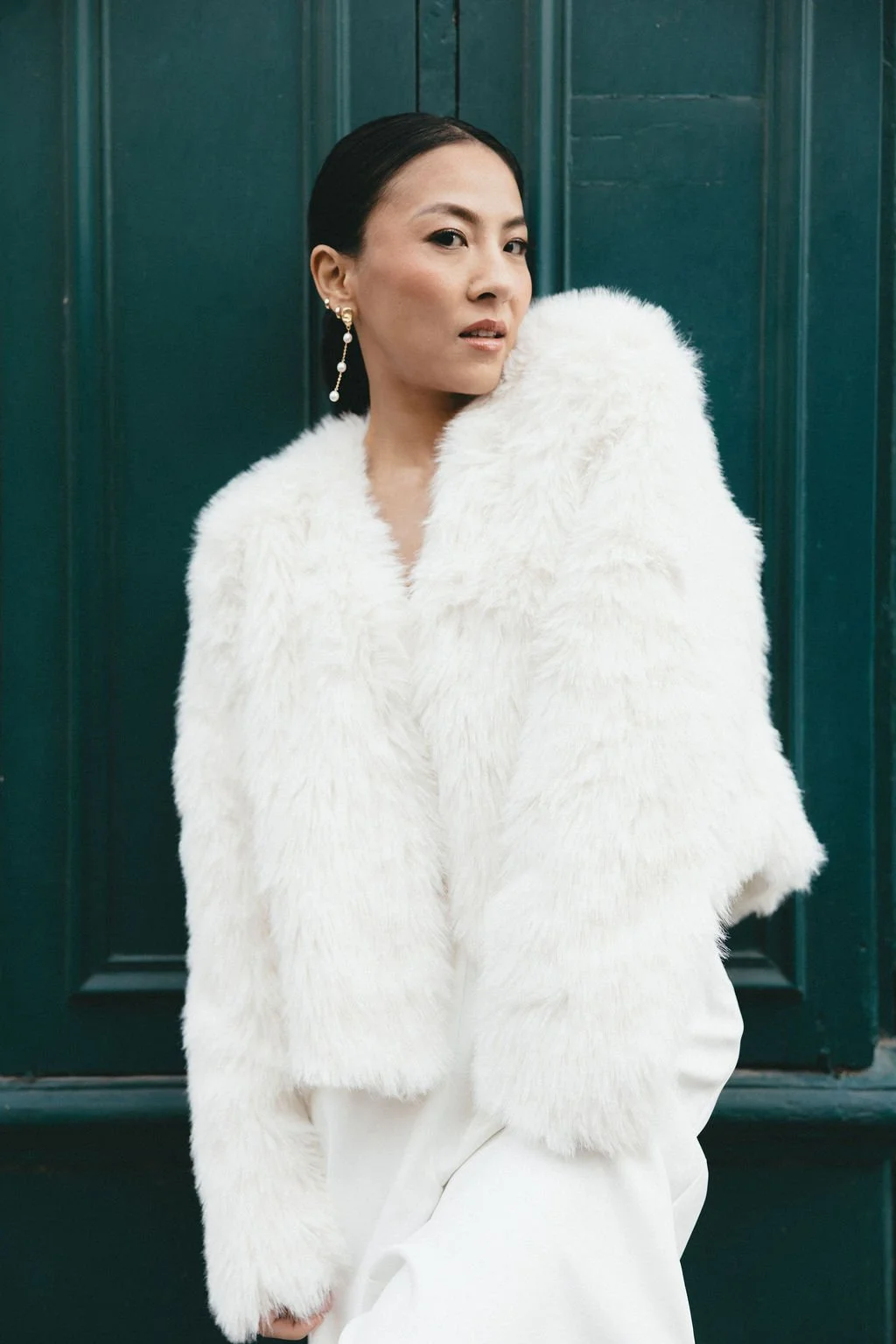 Mariée portant une veste blanche texturée, parfaite pour un mariage d’hiver moderne et raffiné.