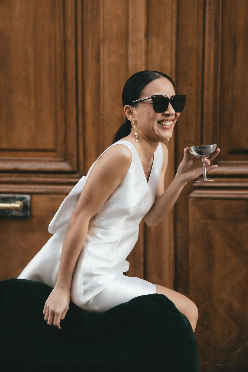 Mariée moderne portant des lunettes de soleil et un cocktail, vision décontractée et élégante du mariage civil.