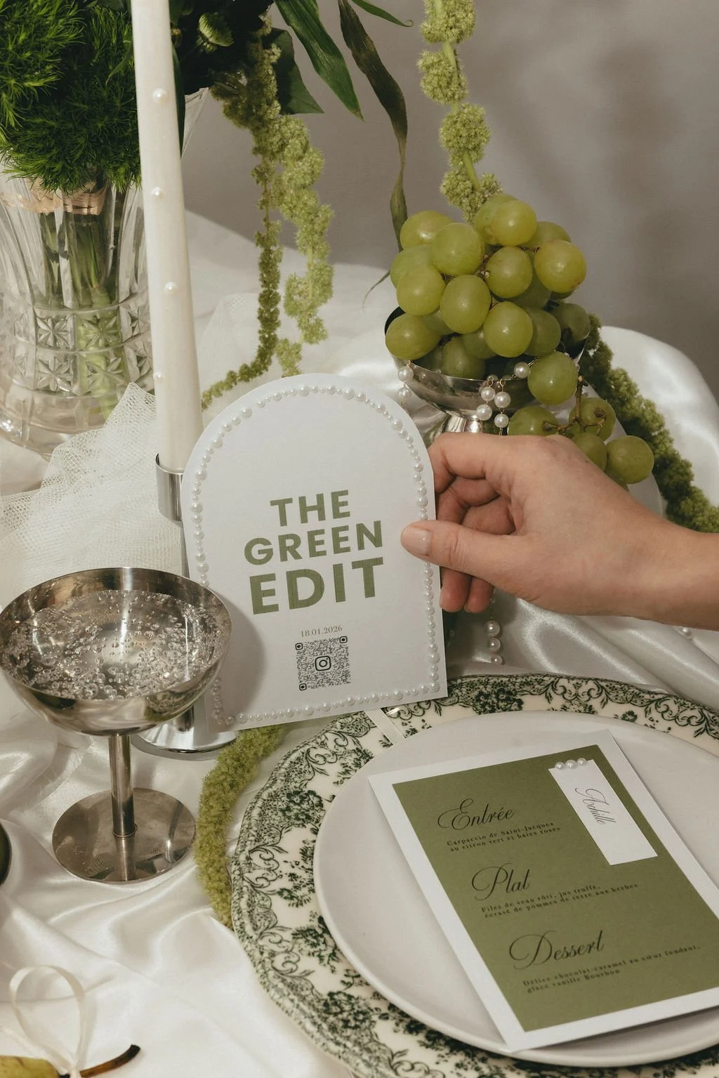 Décoration de table signée THE GREEN EDIT, mêlant fruits verts, papeterie et matières nobles.