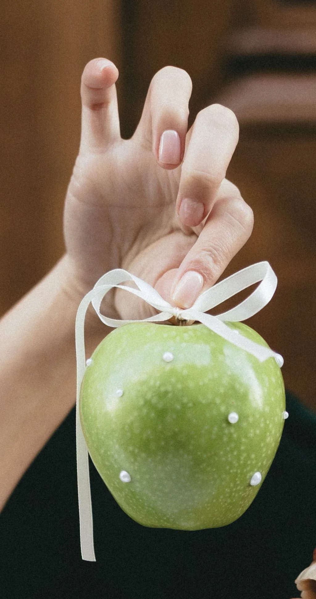 Pomme verte ornée de perles et ruban, détail poétique pour une décoration de mariage élégante.