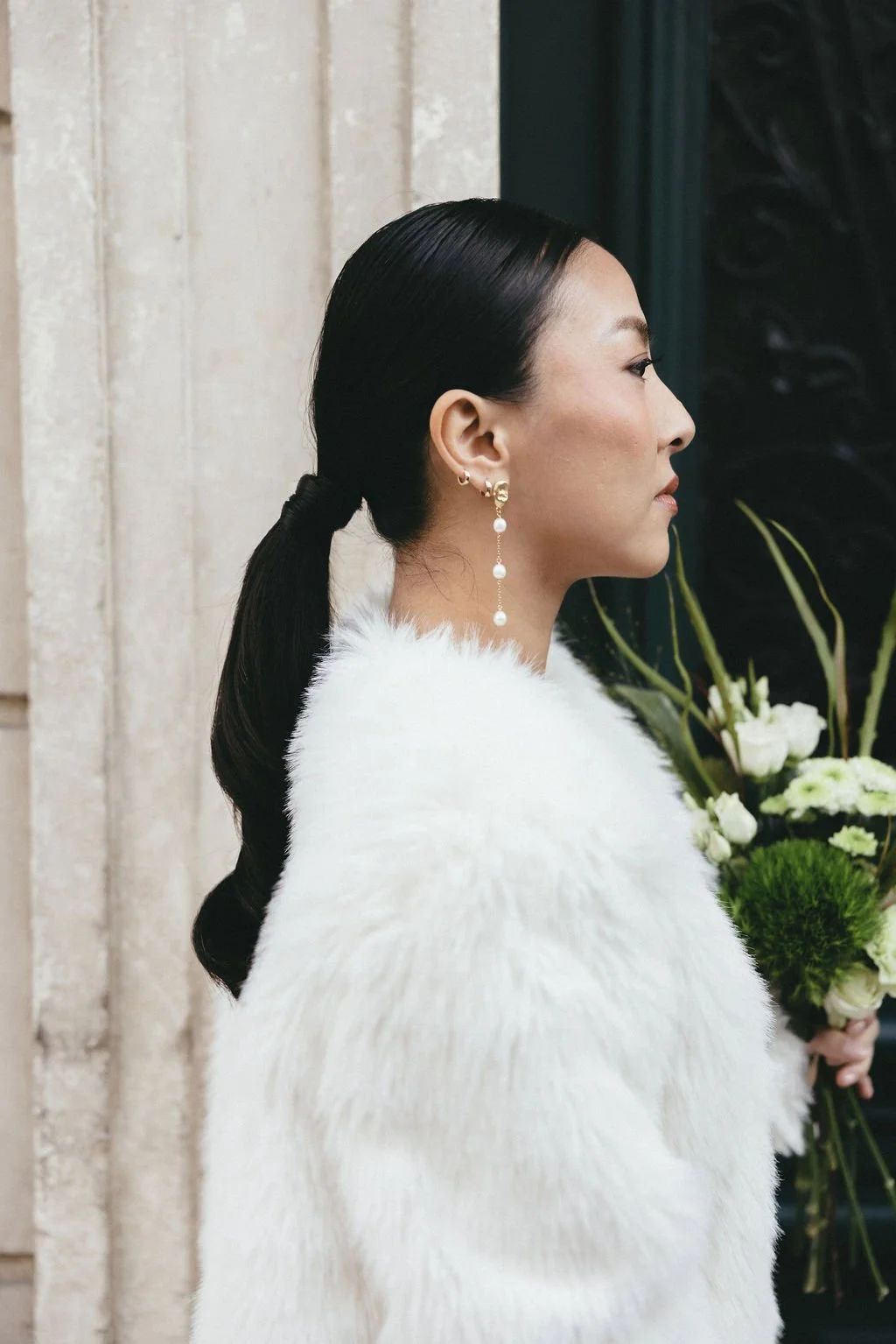 Focus sur la coiffure lisse et moderne de la mariée, détail chic et intemporel.