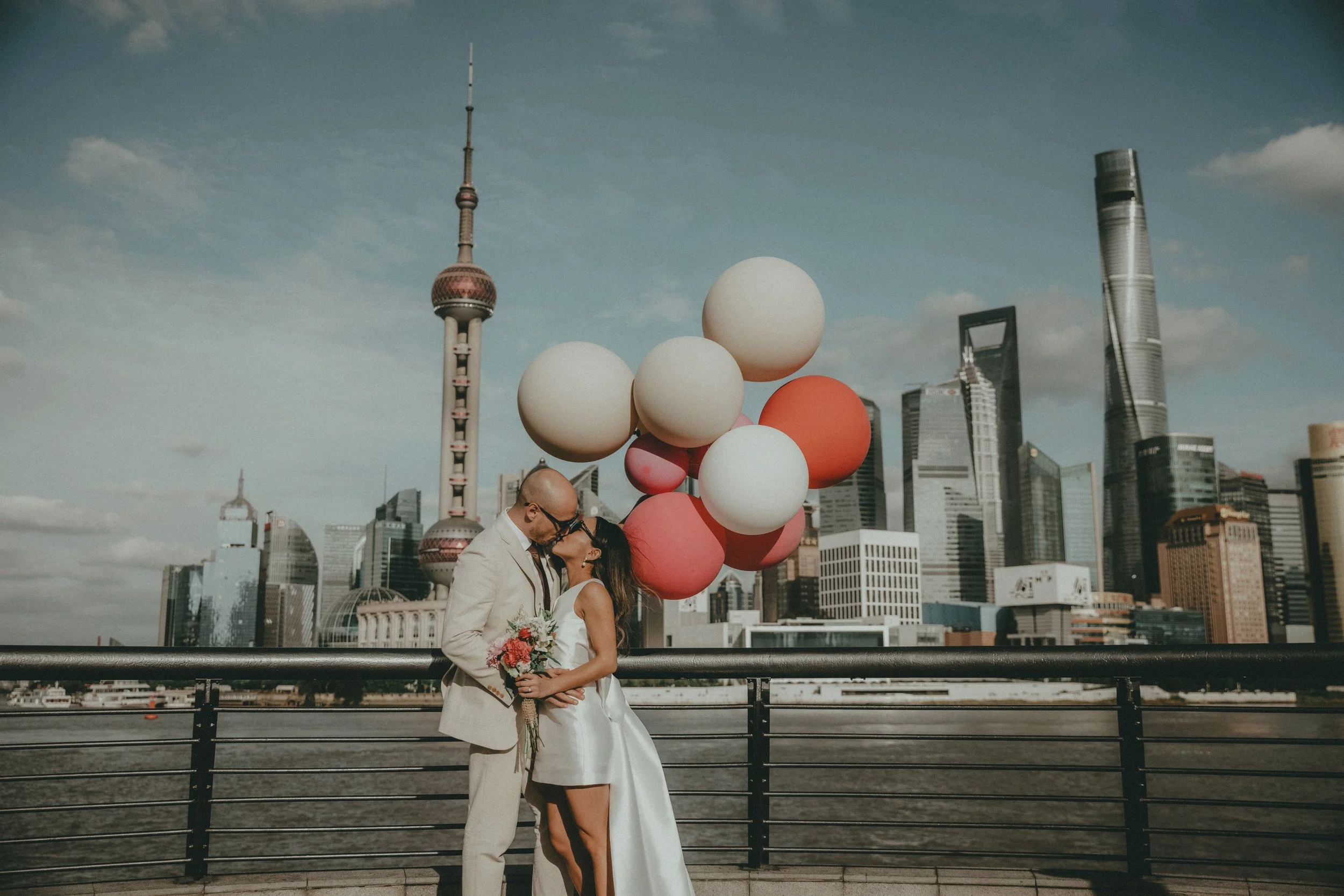 Couple de mariés posant avec des ballons face au skyline de Shanghai — Kahel Wedding Planner