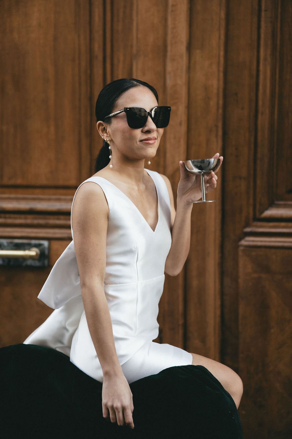 Mariée moderne portant des lunettes de soleil et un cocktail, vision décontractée et élégante du mariage civil.