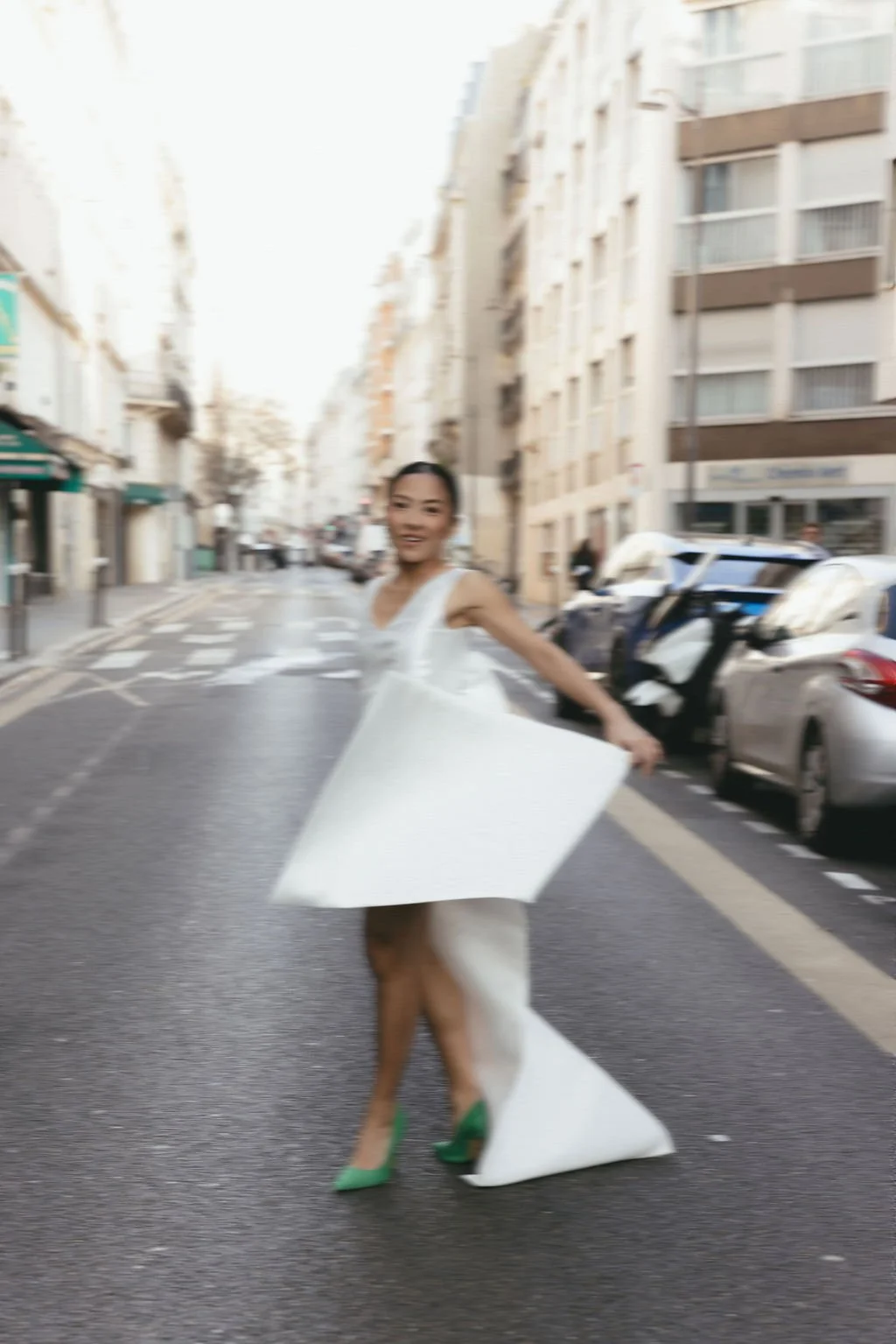 Mariée dansant dans une robe fluide, célébrant la liberté, le mouvement et l’élégance d’un mariage moderne en ville