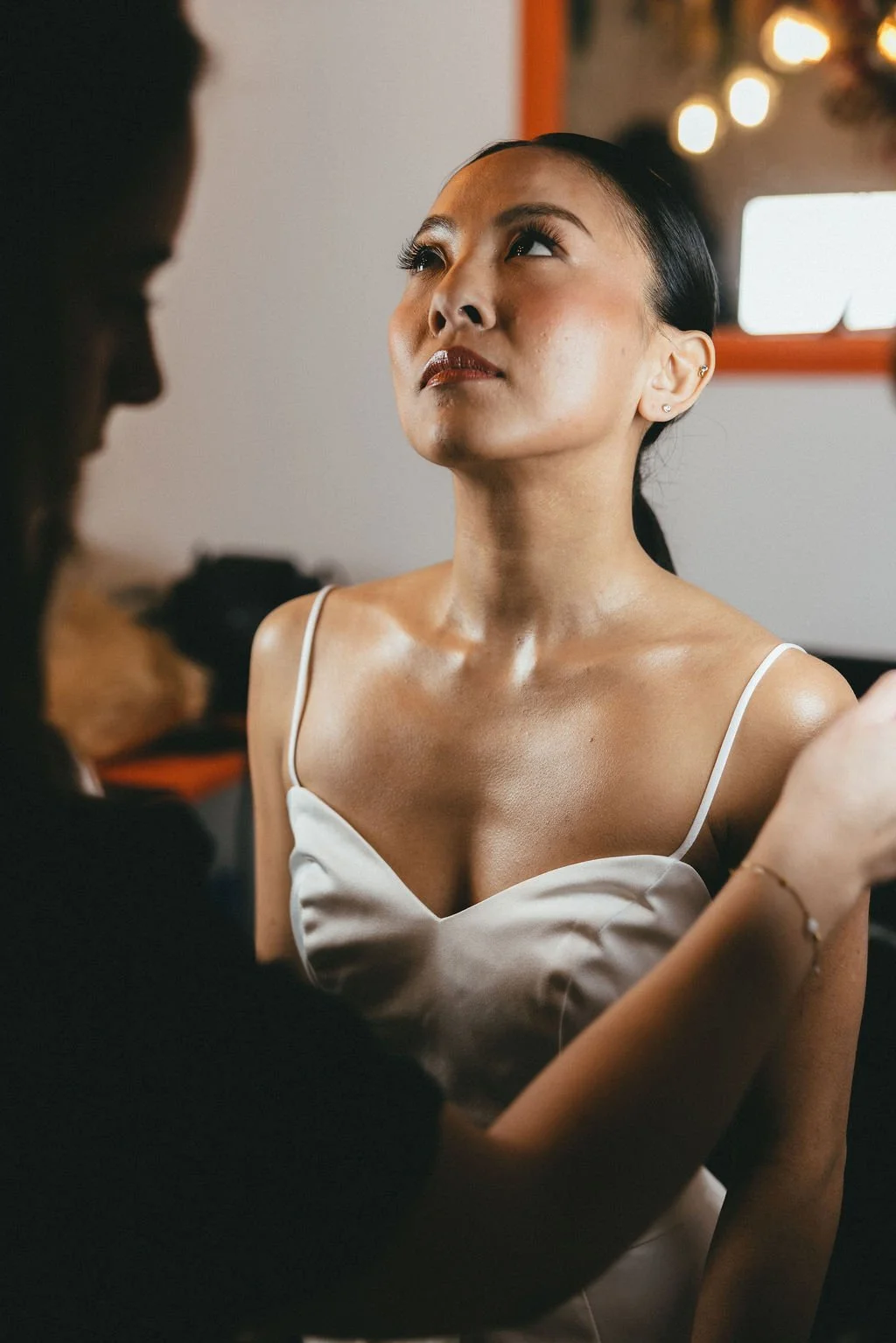 Mariée contemporaine dans un moment backstage, capturant la concentration et l’émotion avant le mariage.