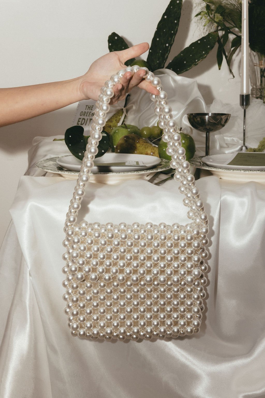 Sac en perles posé sur une table de mariage, détail chic et couture.