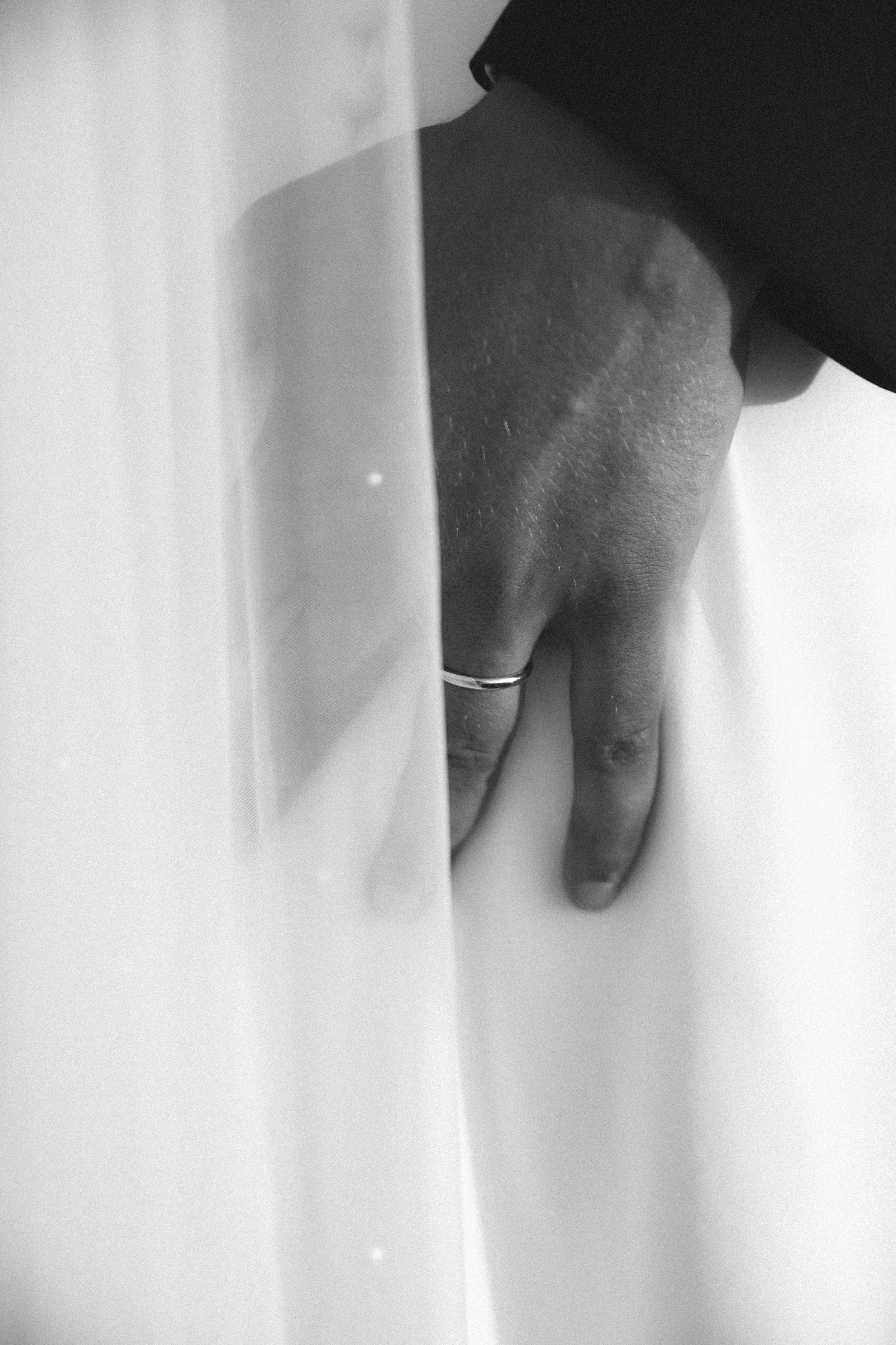 Détail de la main du marié sous le voile de la mariée— Kahel Wedding Planner
