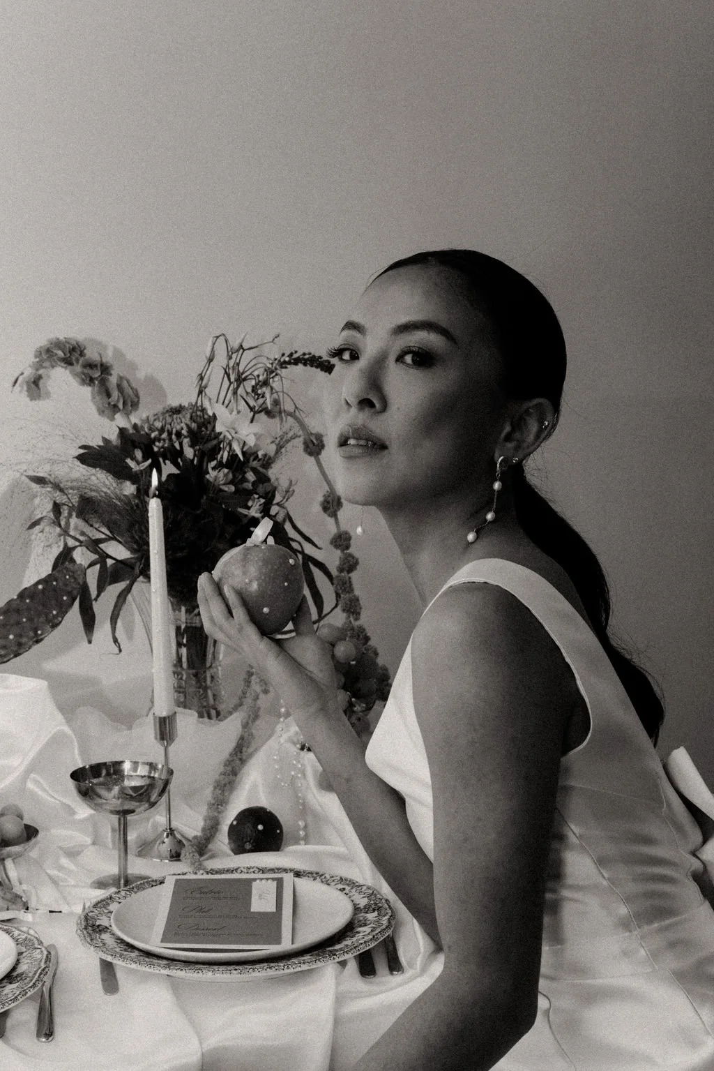 Mariée tenant une coupe, scène de table moderne et raffinée.