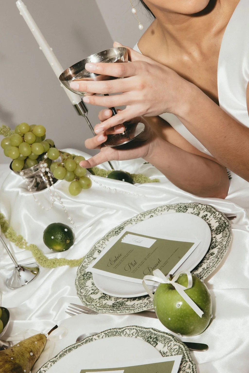 Mariée tenant une coupe, scène de table moderne et raffinée.