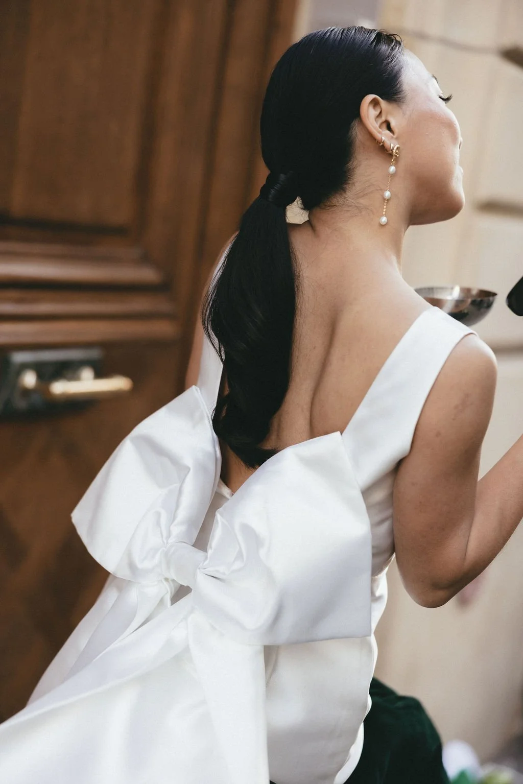 Zoom sur le dos structuré de la robe, nœud graphique et élégance contemporaine.