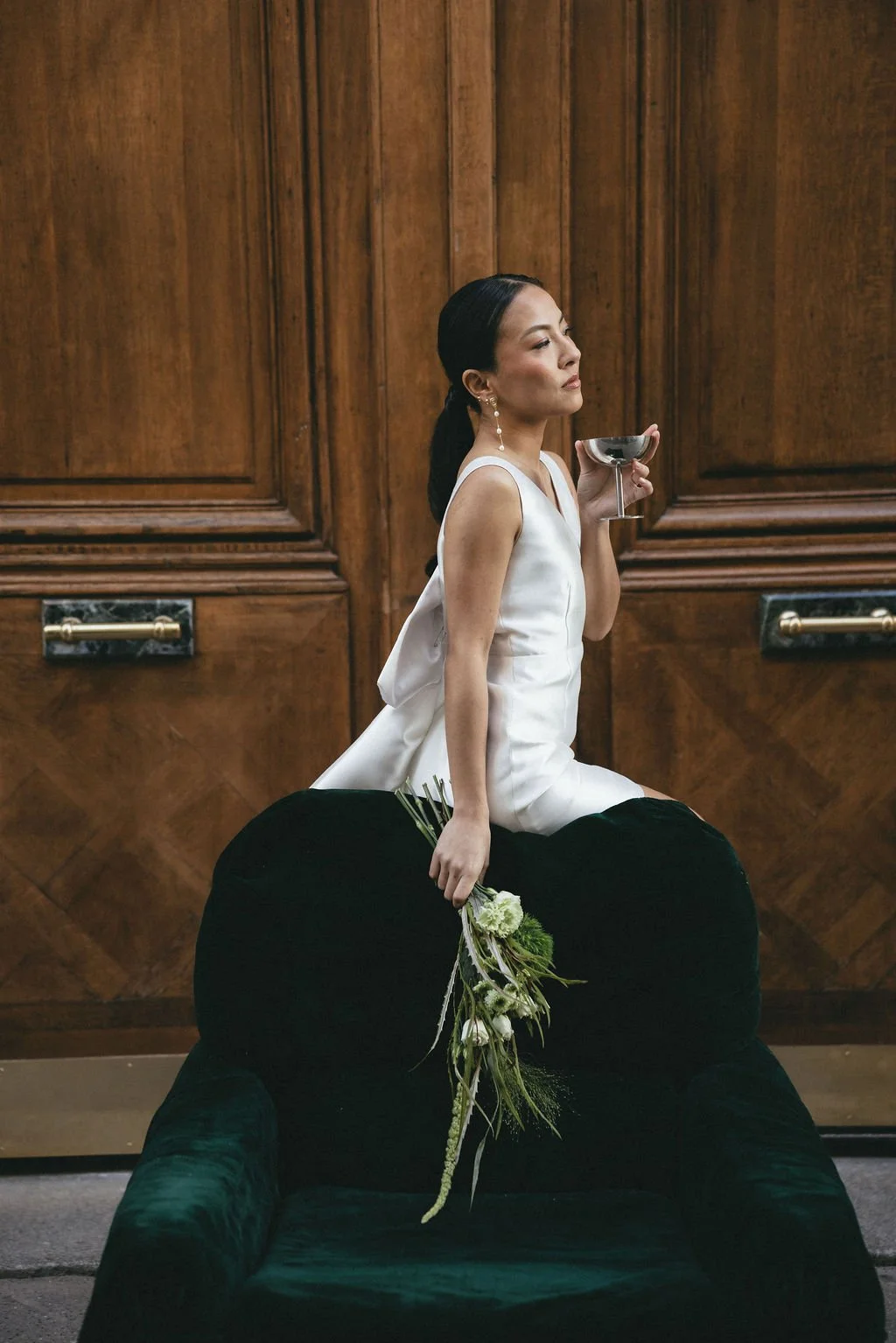 Mariée assise tenant un verre, clin d’œil moderne et décontracté au mariage civil.